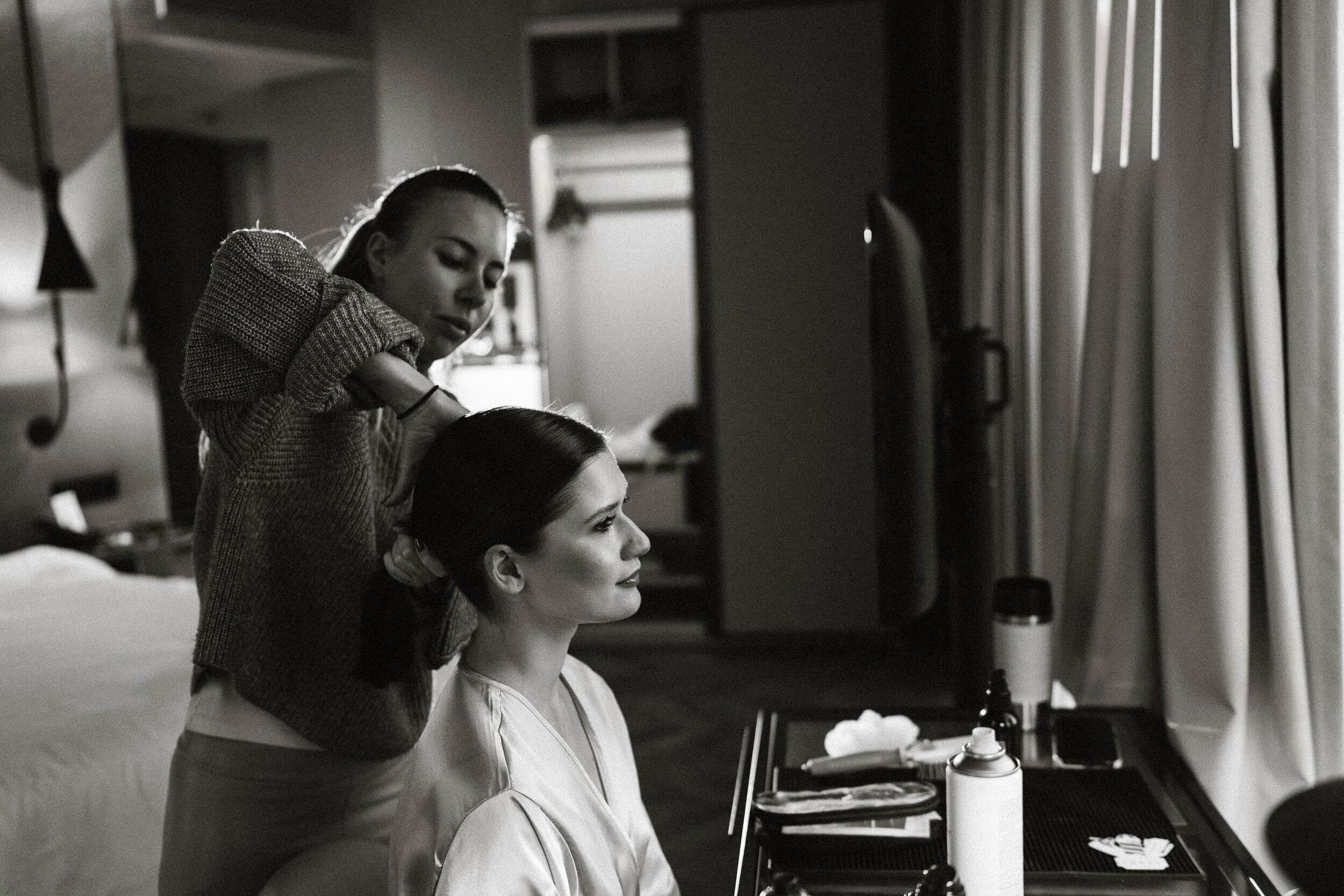 make up artist preparing the bride at hotel