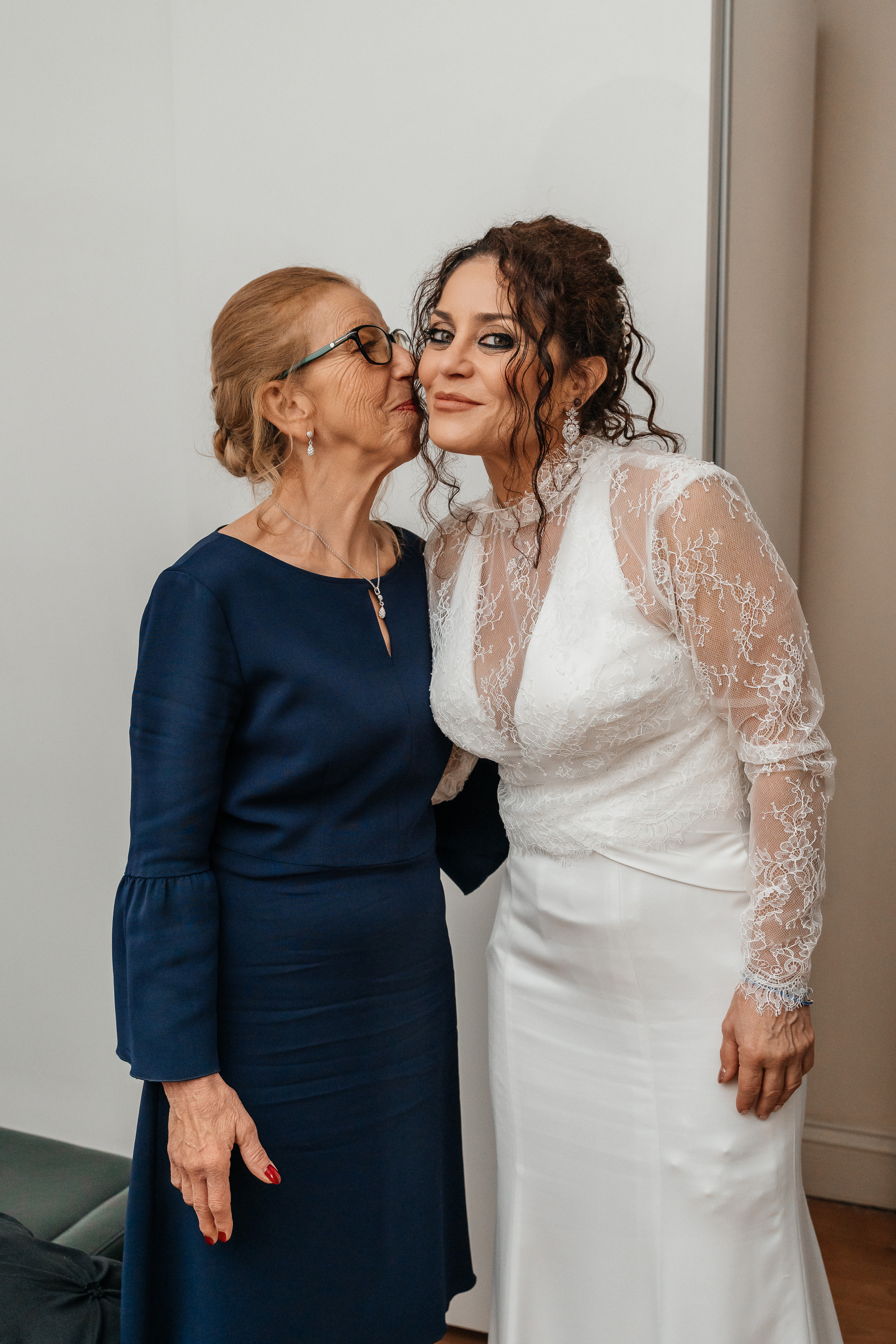 Mother of the bride kisses the bride before an important day
