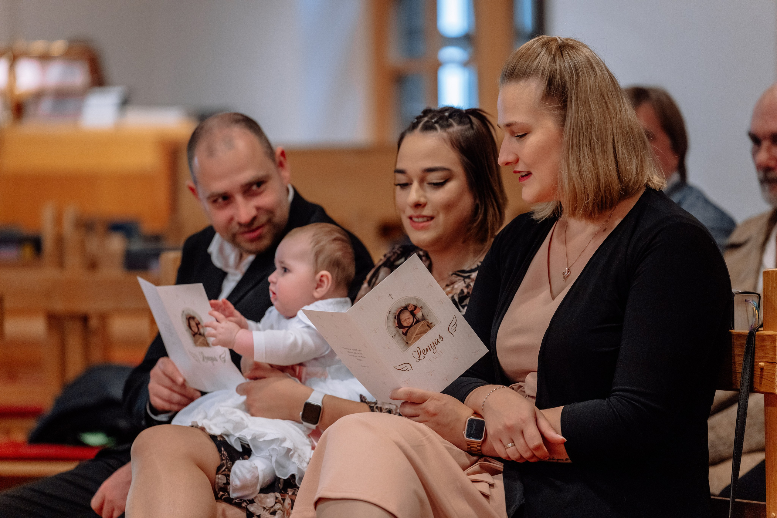 Eltern und Gäste beten zusammen während der Taufe