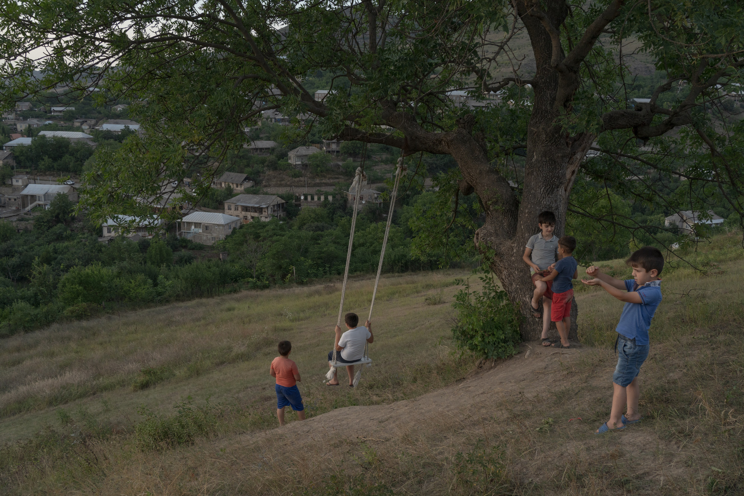 In the summer, the children of Chinari, a bordering village with Azerbaijan, spend a lot of time playing outside together. Here, they are pictured at one of their favorite spots, on the top of the steep hill that overlooks the entire village. On a clear day, the homes of the Azerbaijani people can be visible from afar.