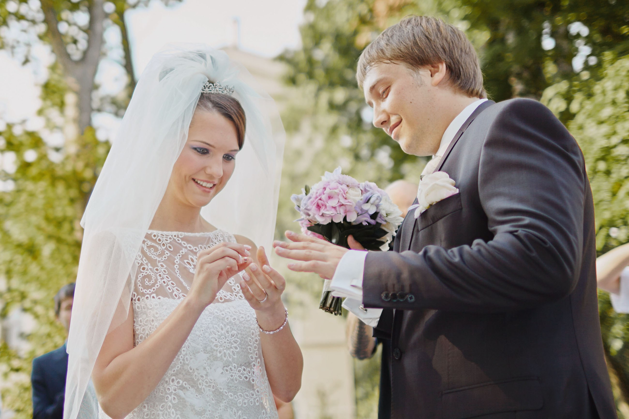 Romantic ring exchange at outdoor Czech chateau wedding.