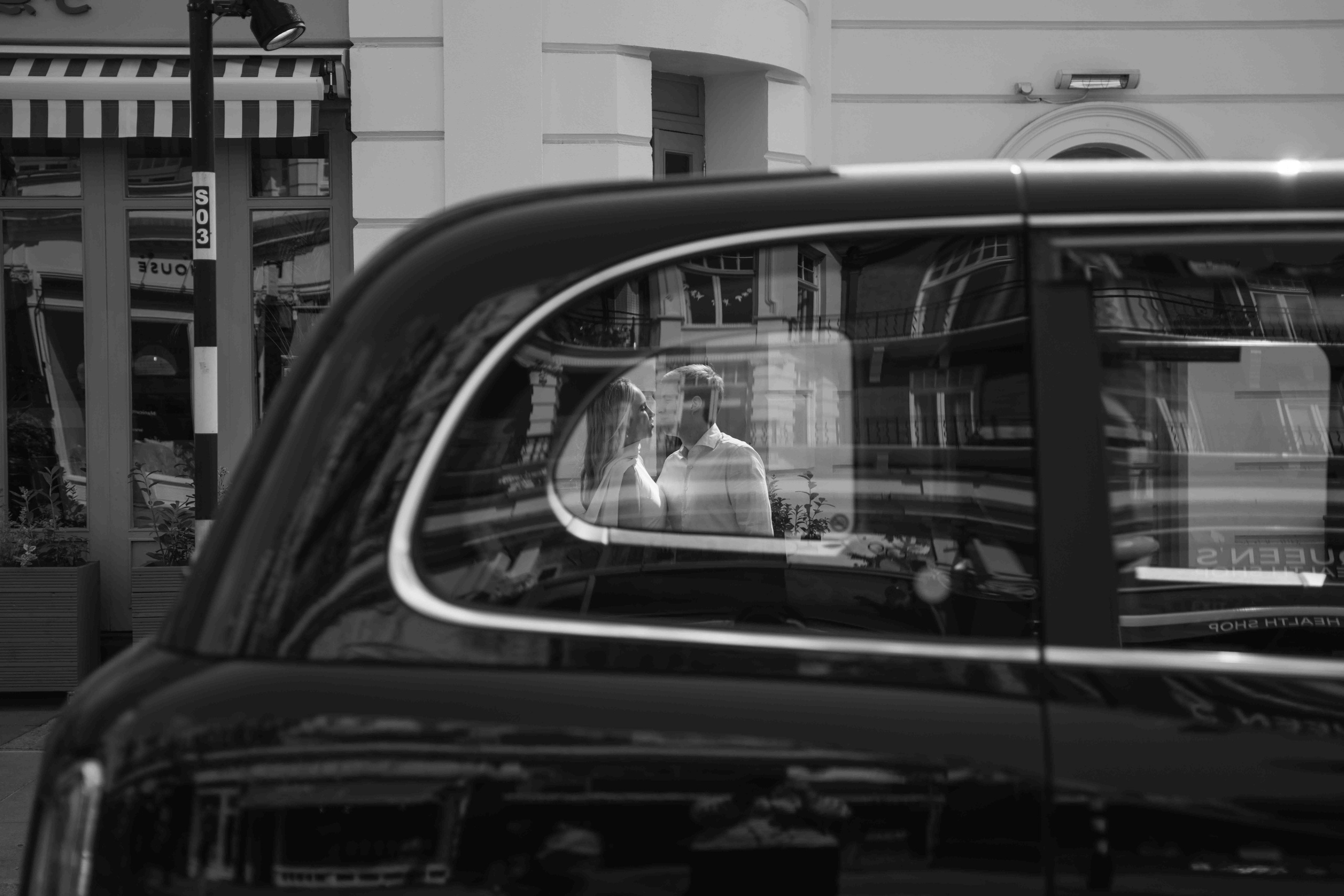 Couple reflected in a car window during South Kensington London photoshoot
