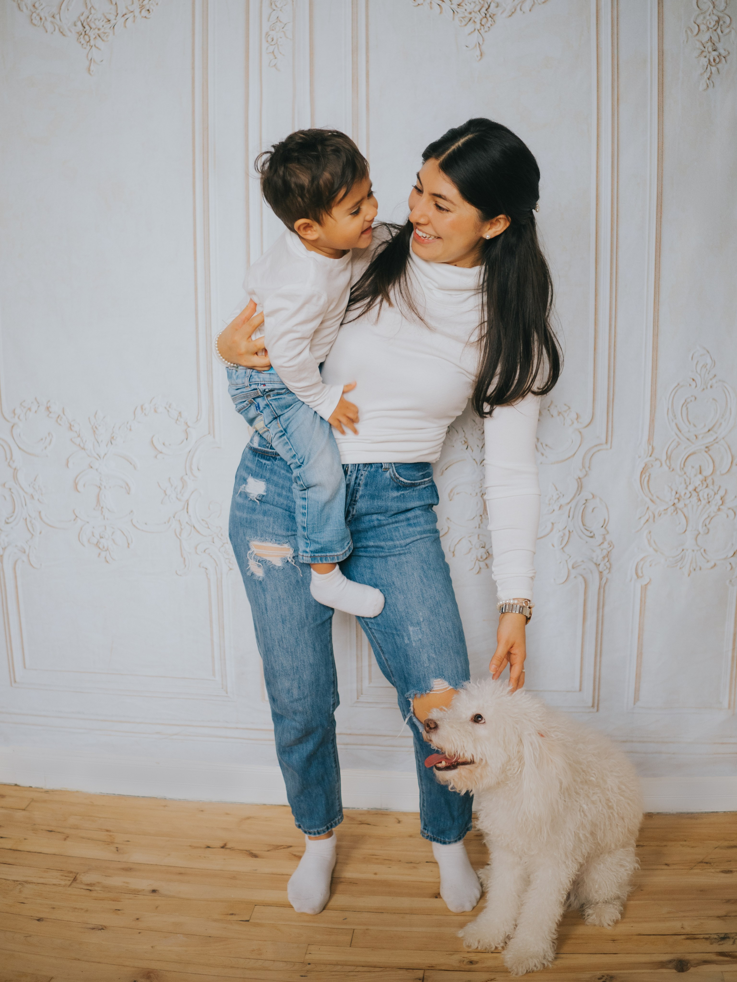 Mère, fils et chien devant un mur vintage.
