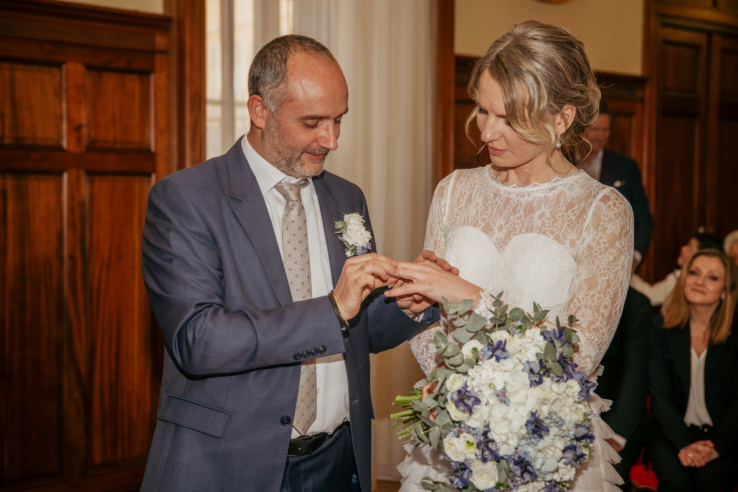 Le marié passe la bague de mariage au doigt de la mariée.