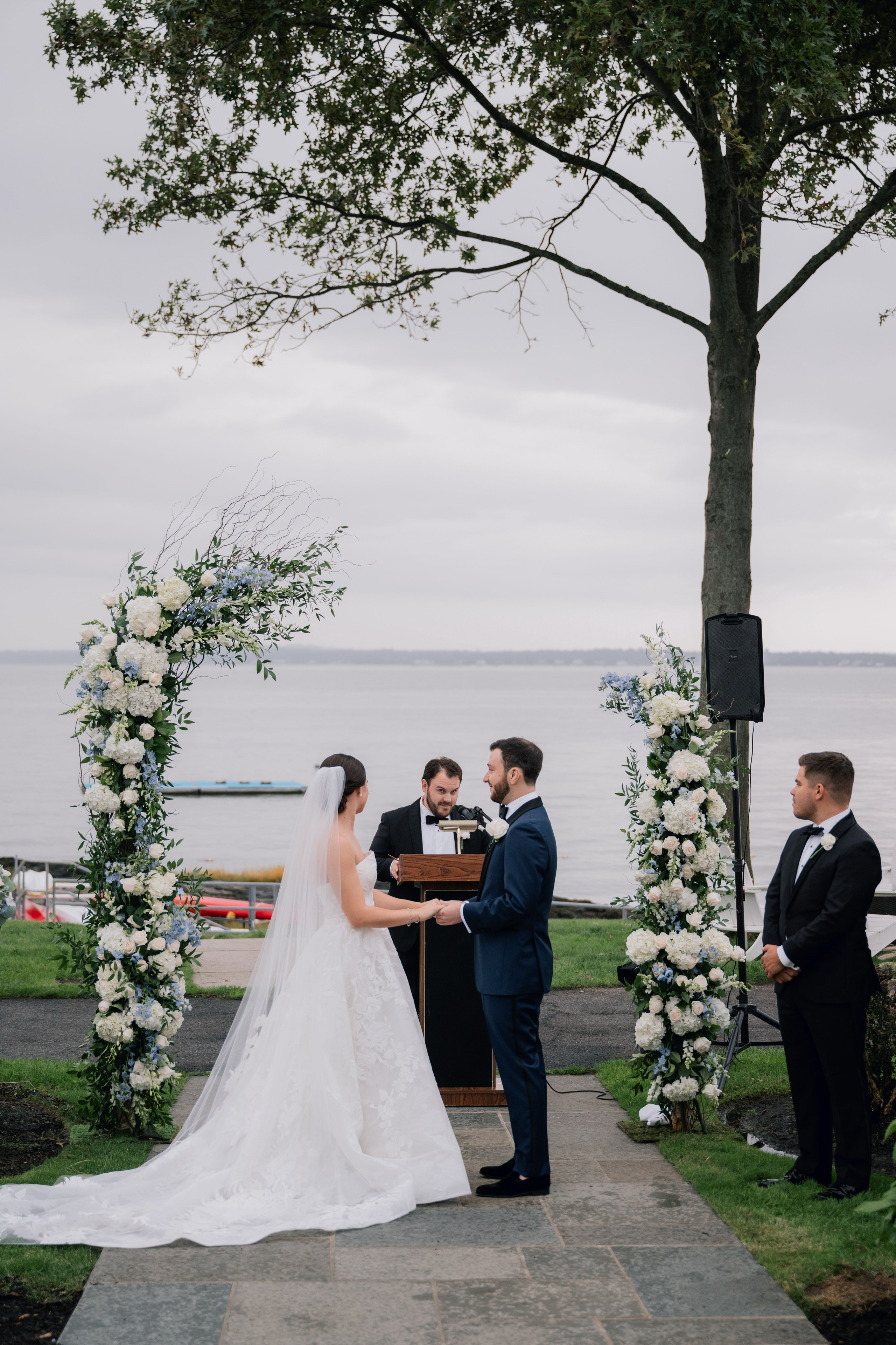 a bride and groom are standing under a tree