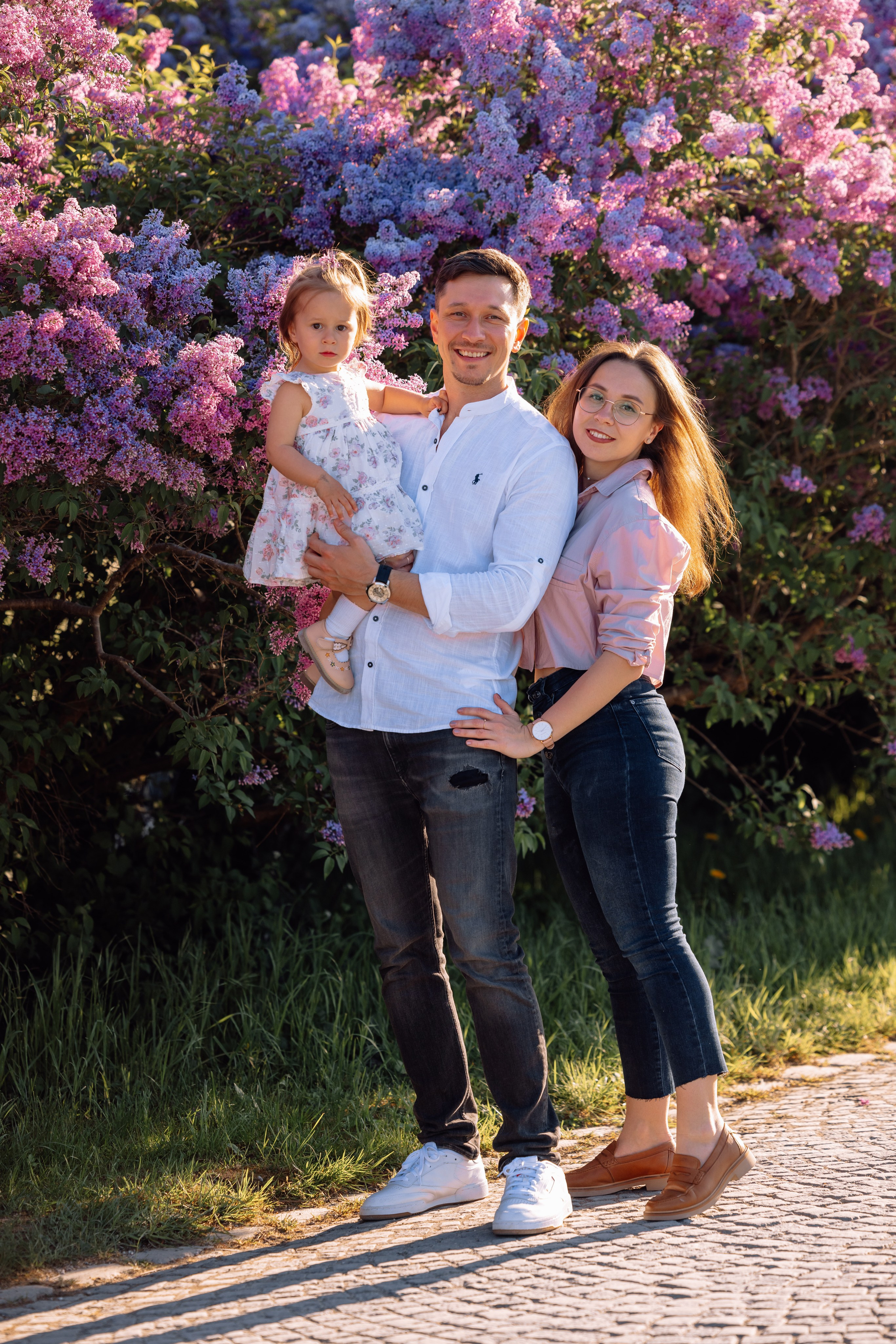 Familie umarmt sich liebevoll beim Spaziergang durch den Park vom Schloss Nymphenburg