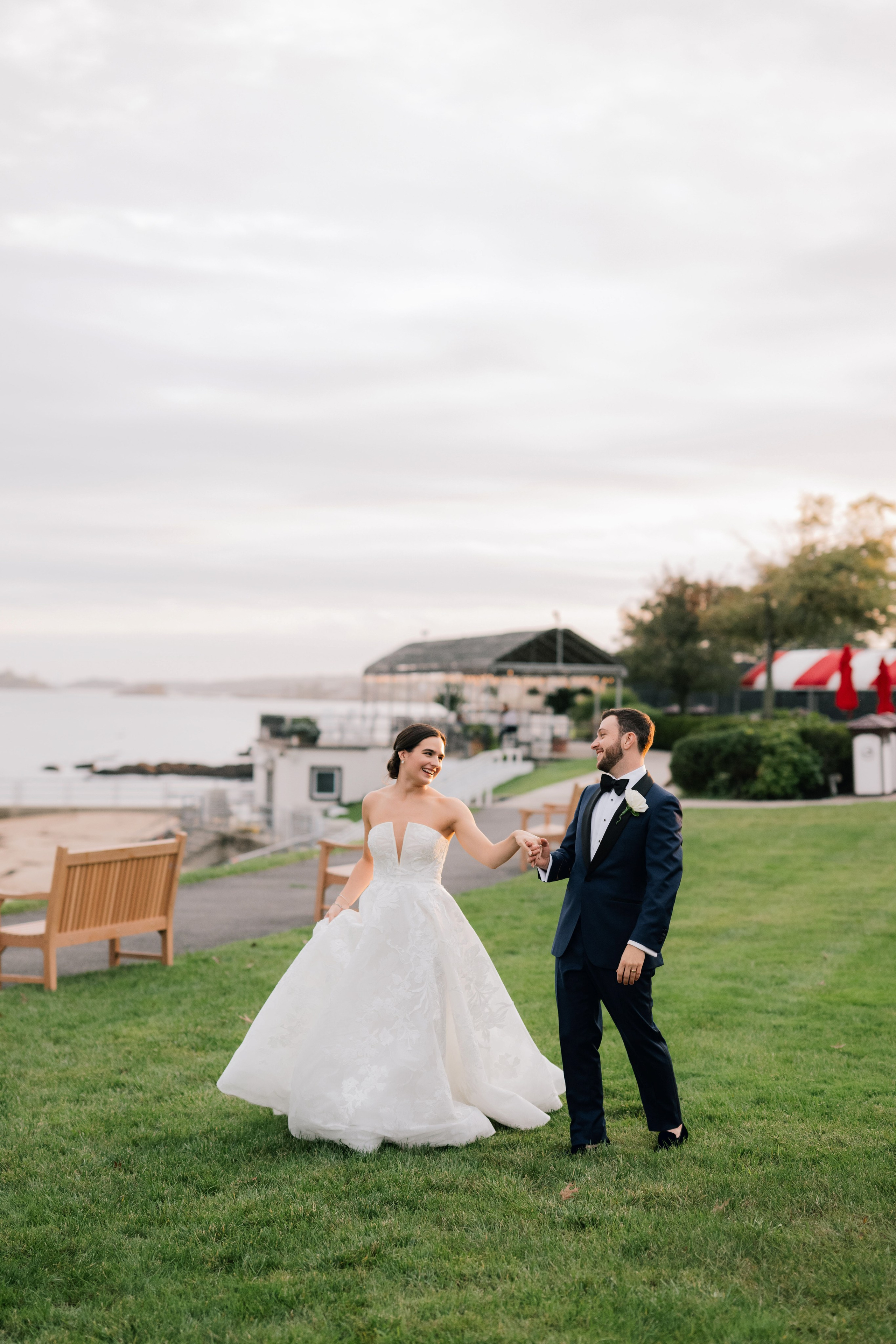 a bride and groom walking in the grass
