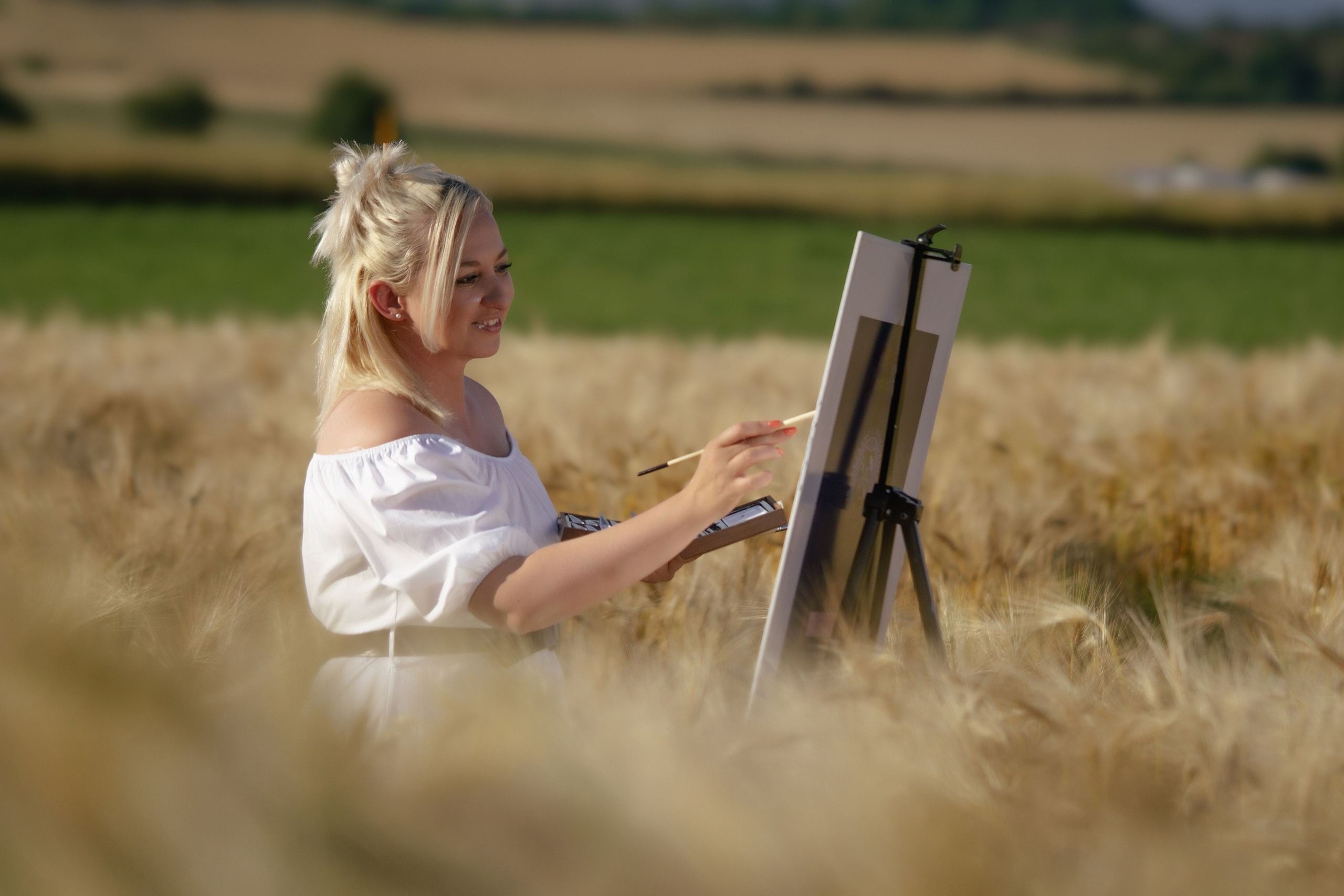 Künstlerin, die draußen in der Natur an einem Kunstwerk arbeitet