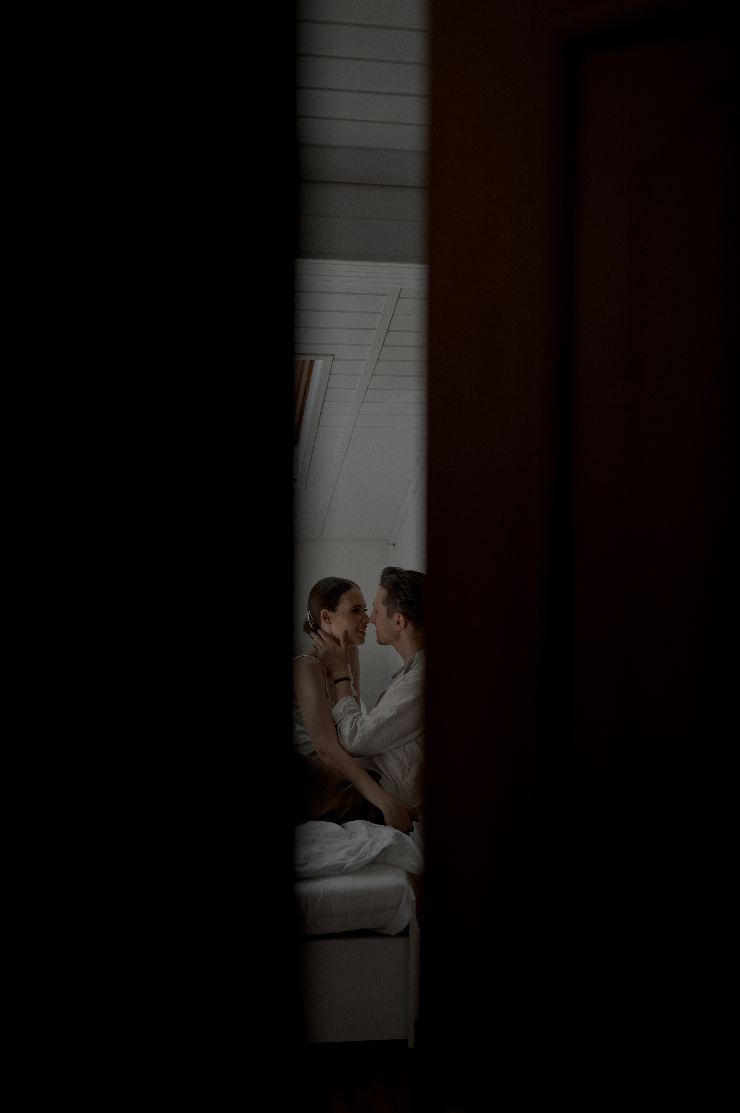 Cozy start to the wedding day as the couple cherishes intimate moments in bed, radiating love and eager anticipation