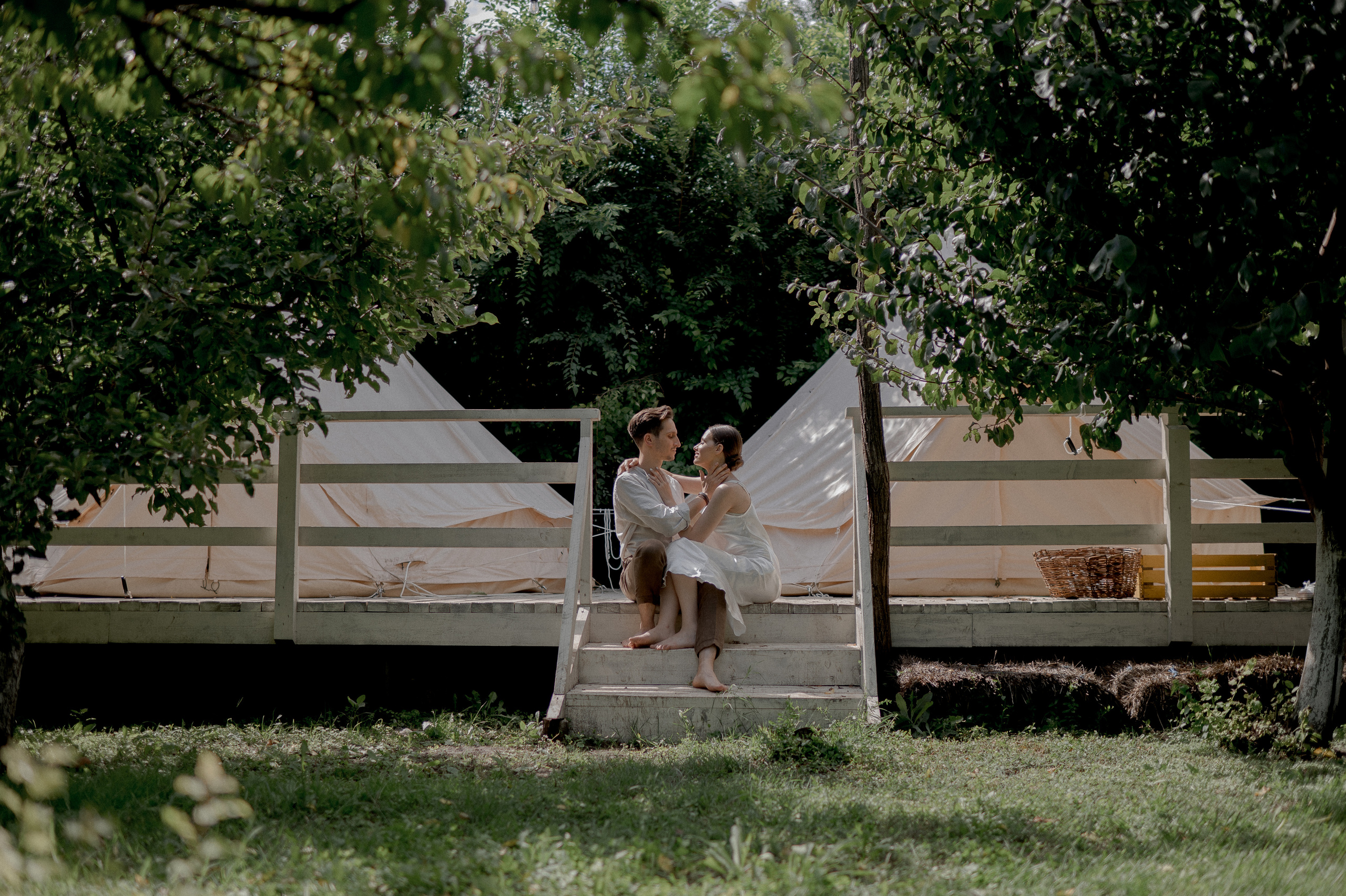 Within the secluded beauty of a garden paradise, the couple's wedding morning begins in the enchanting ambiance of glamping tents, fostering an atmosphere of intimacy and love.