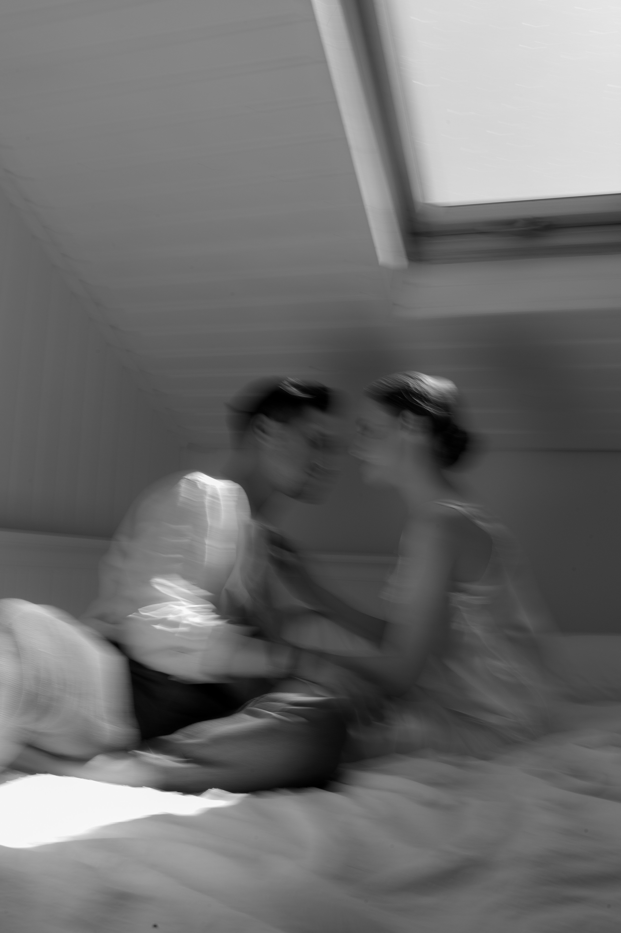 Through the skillful use of a slow shutter speed, the photographer beautifully captures the intimate wedding morning of the couple in bed, emanating love and anticipation for their joyous celebration.