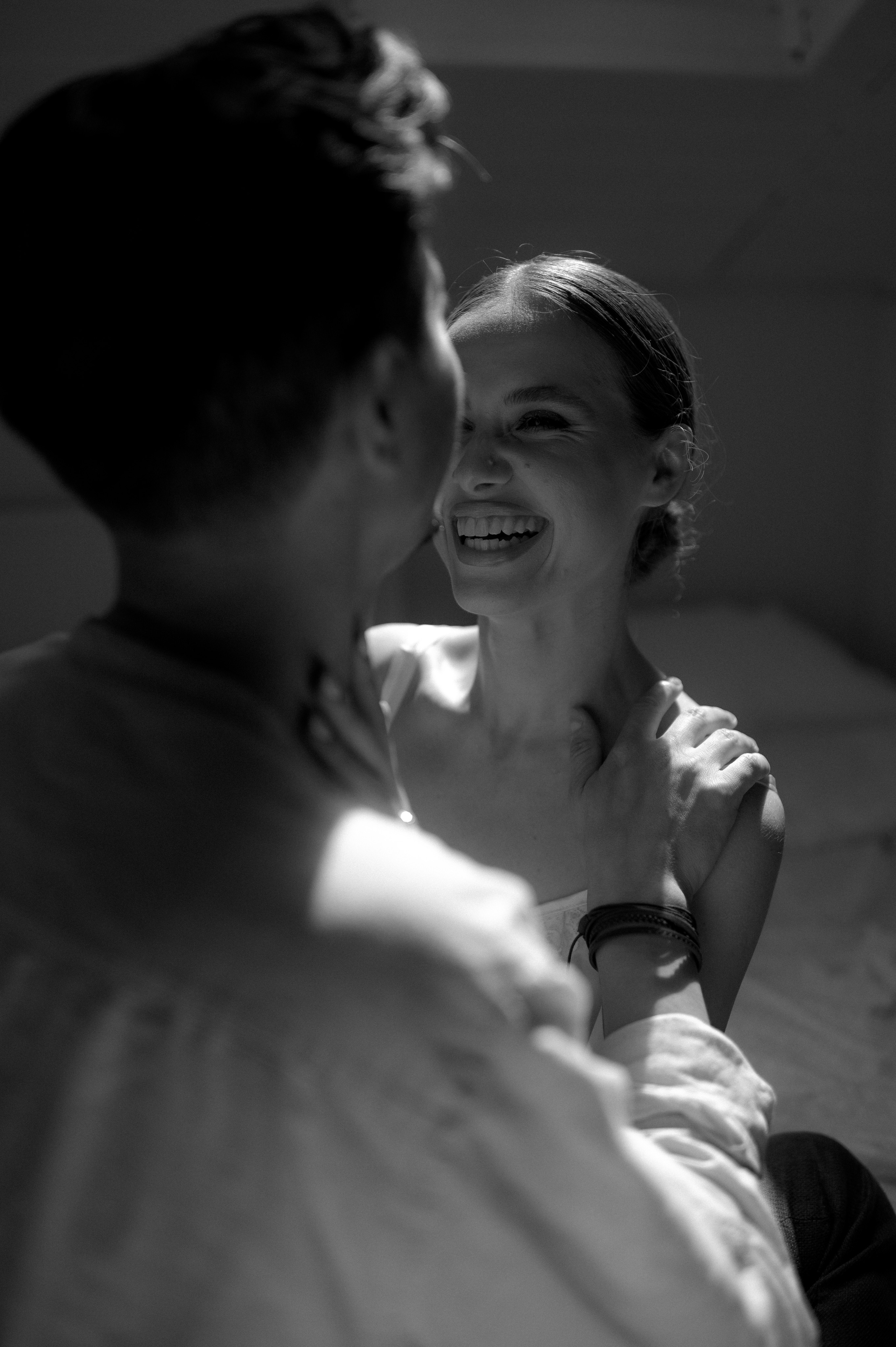 In a moment of pure joy, the couple shares a laughter-filled kiss in the room, their happiness echoing through the captured image.
