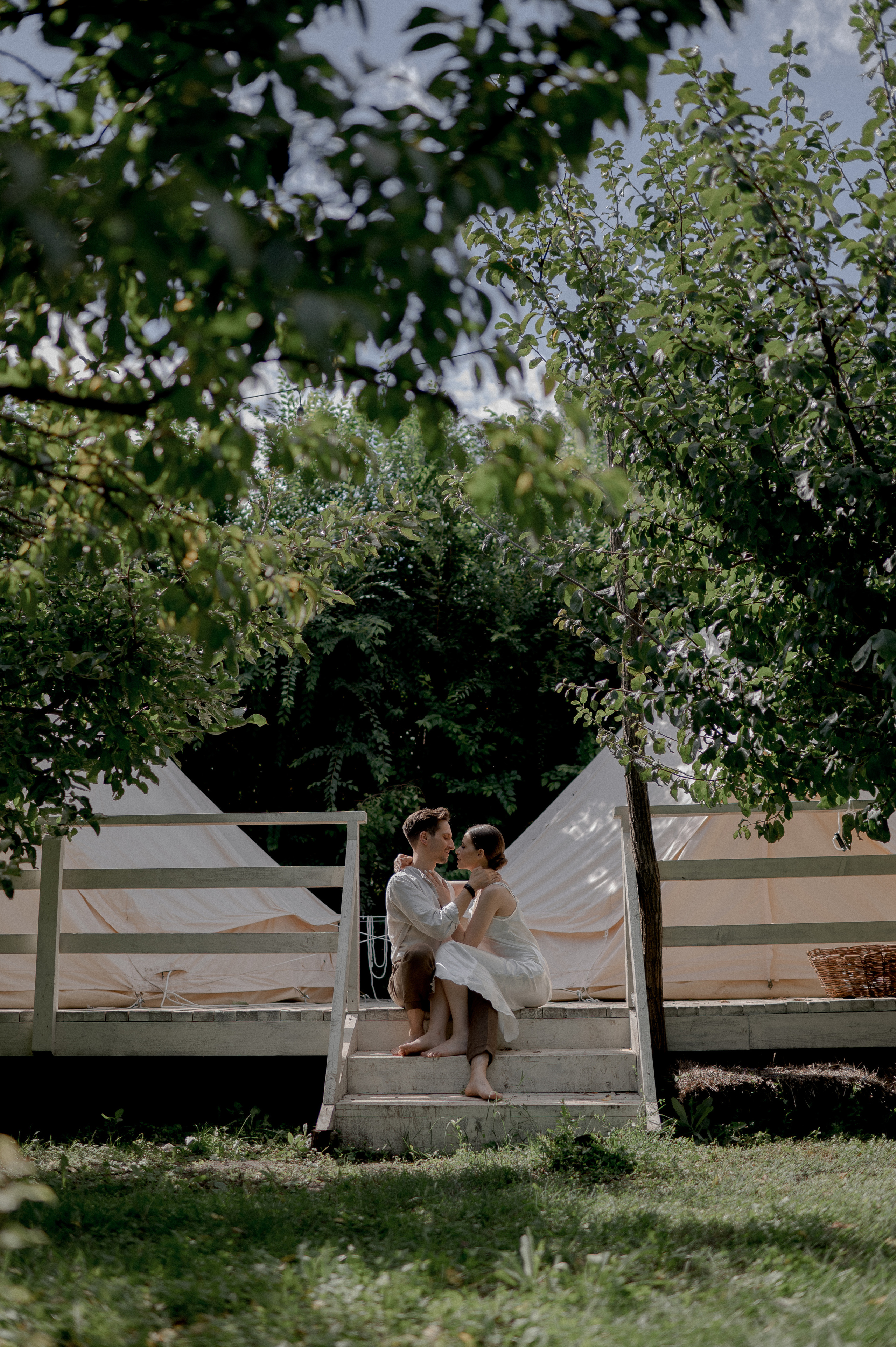 Nestled in a secluded garden haven, the couple shares a blissful wedding morning in the comfort of glamping tents, reveling in the loving and tender connection they share.