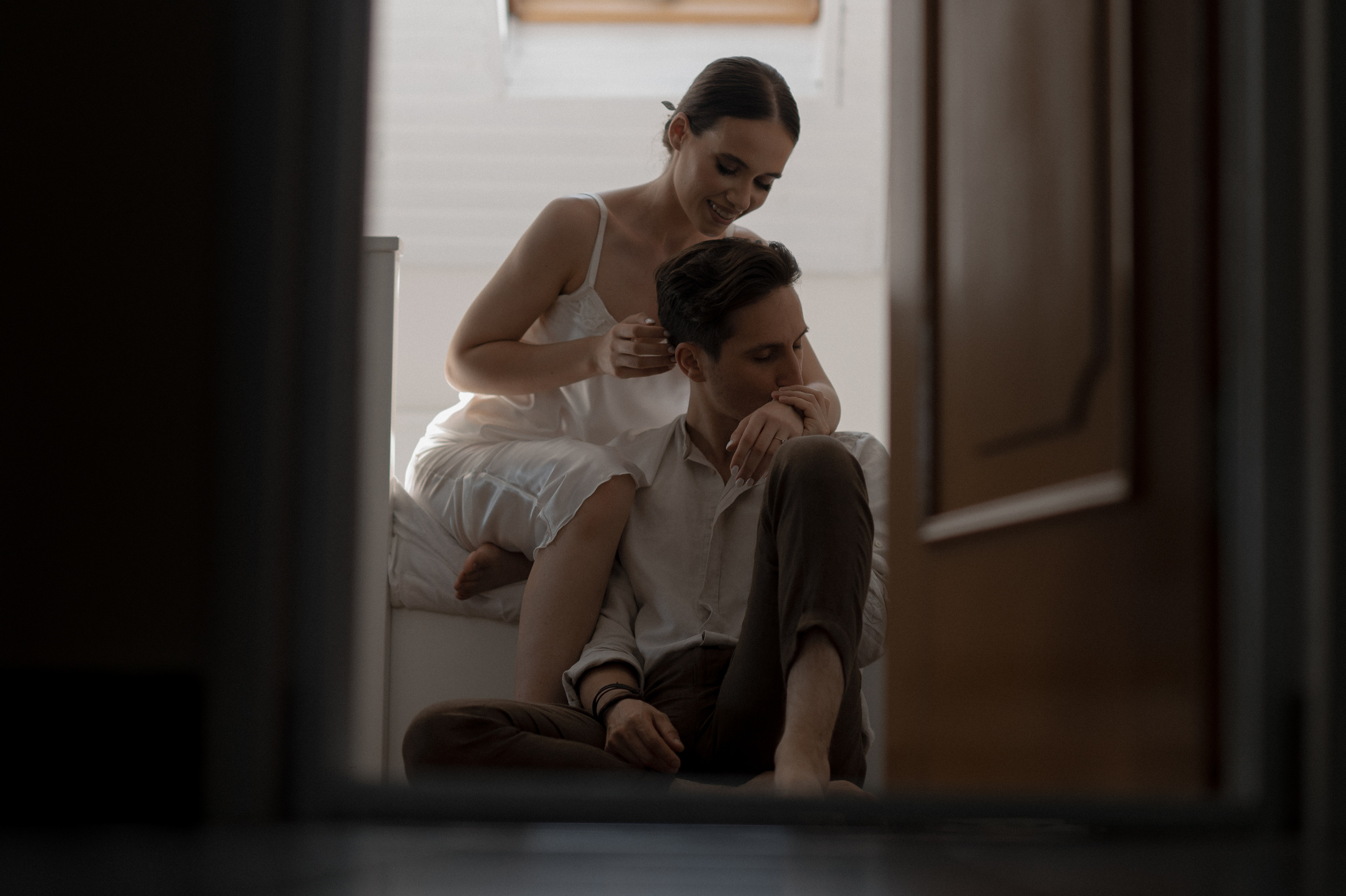 A romantic awakening as the couple embraces in bed, filled with love and excitement for their wedding day journey together.