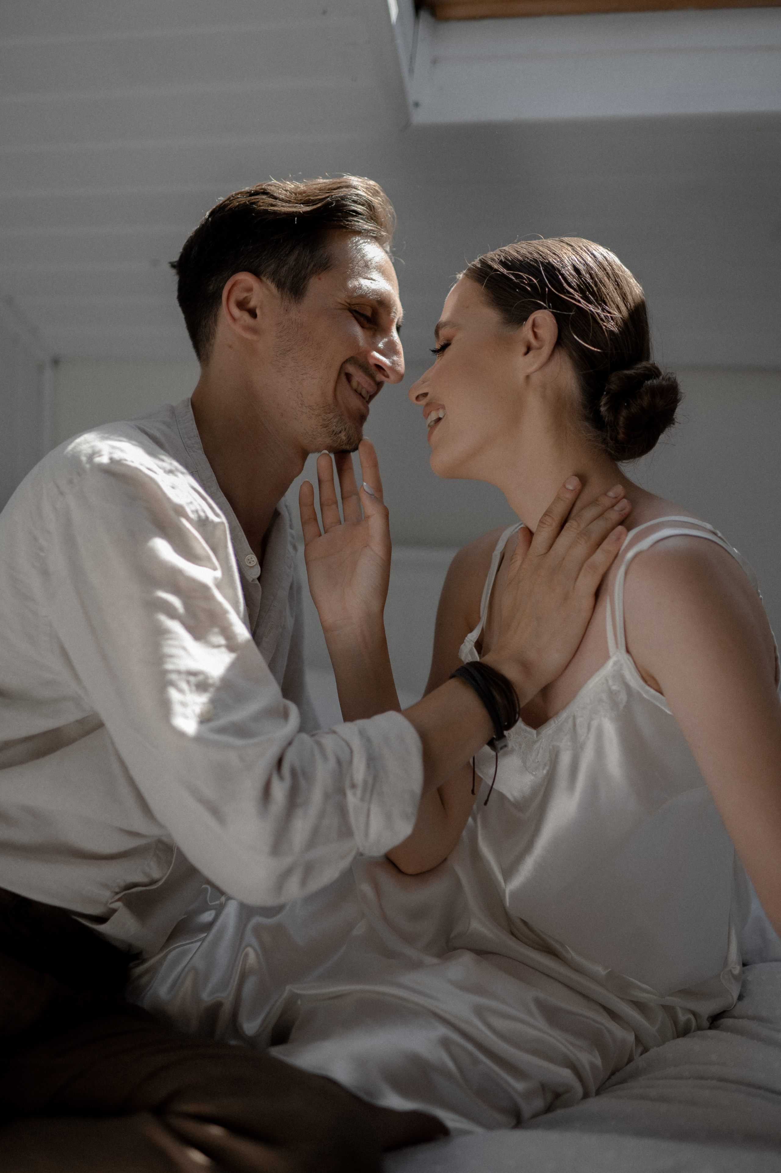 Captivating morning tenderness as the couple embraces in bed, filled with love and excitement for their joyous wedding ceremony.