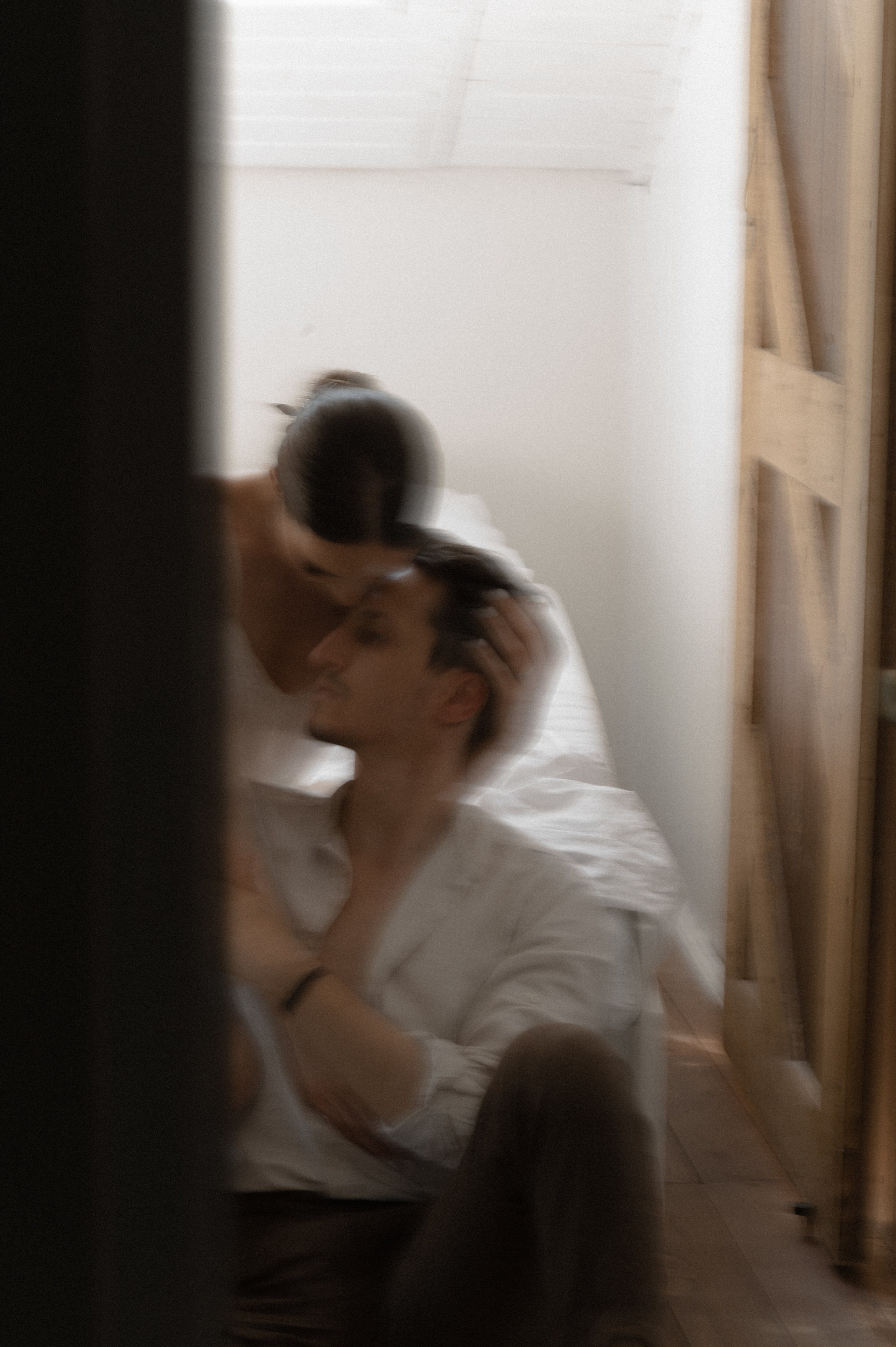 The photographer skillfully employs a slow shutter speed to capture the couple's affectionate kiss in the room, enhancing the romantic ambiance and preserving the depth of their connection.