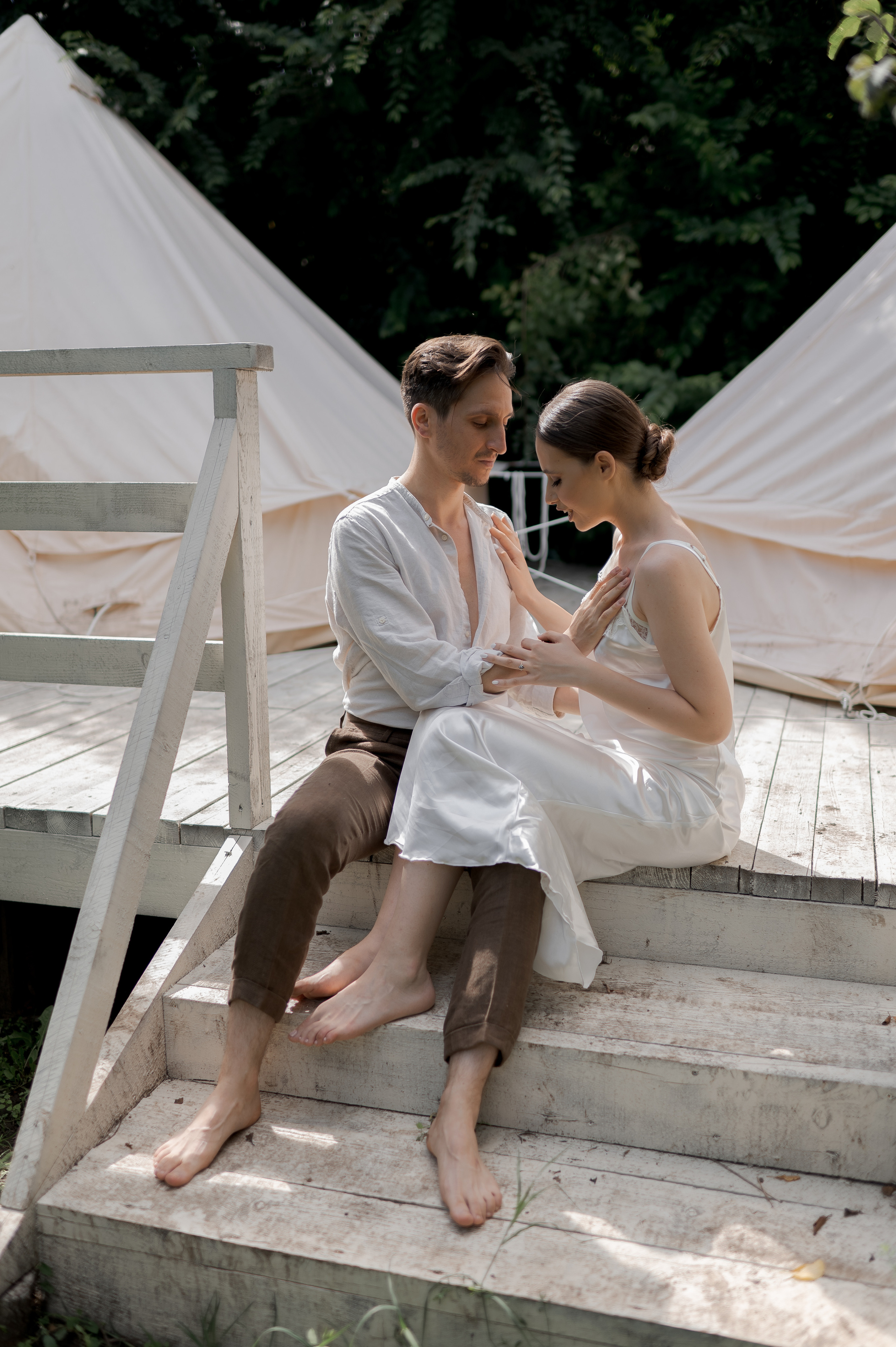 Amidst the tranquil beauty of a secluded garden, the couple experiences the intimacy of their wedding morning, nestled in cozy glamping tents, their love radiating with every touch.