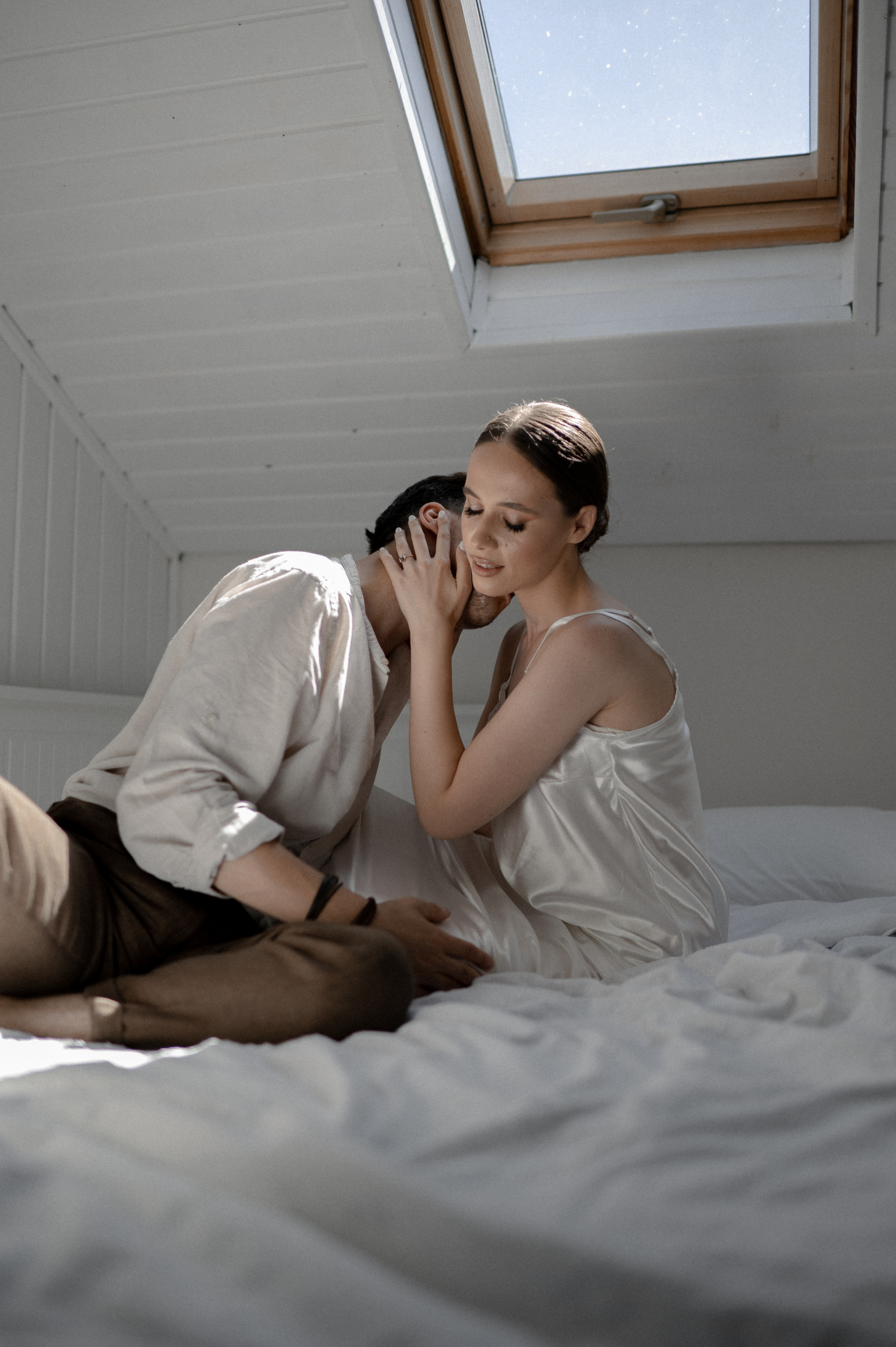 Cozy morning bliss unfolds as the couple embraces in bed, savoring precious moments of love and anticipation on their wedding day.
