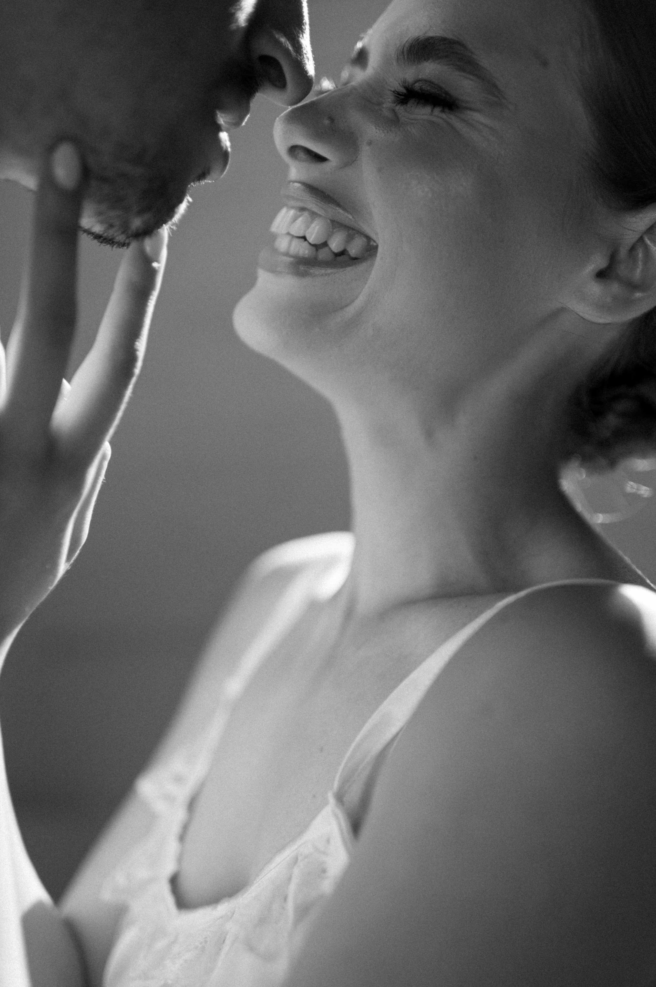 In a heartwarming moment, the couple bursts into laughter while sharing a tender kiss, the shimmering stone on their distinctive engagement ring adding a touch of elegance to the scene.