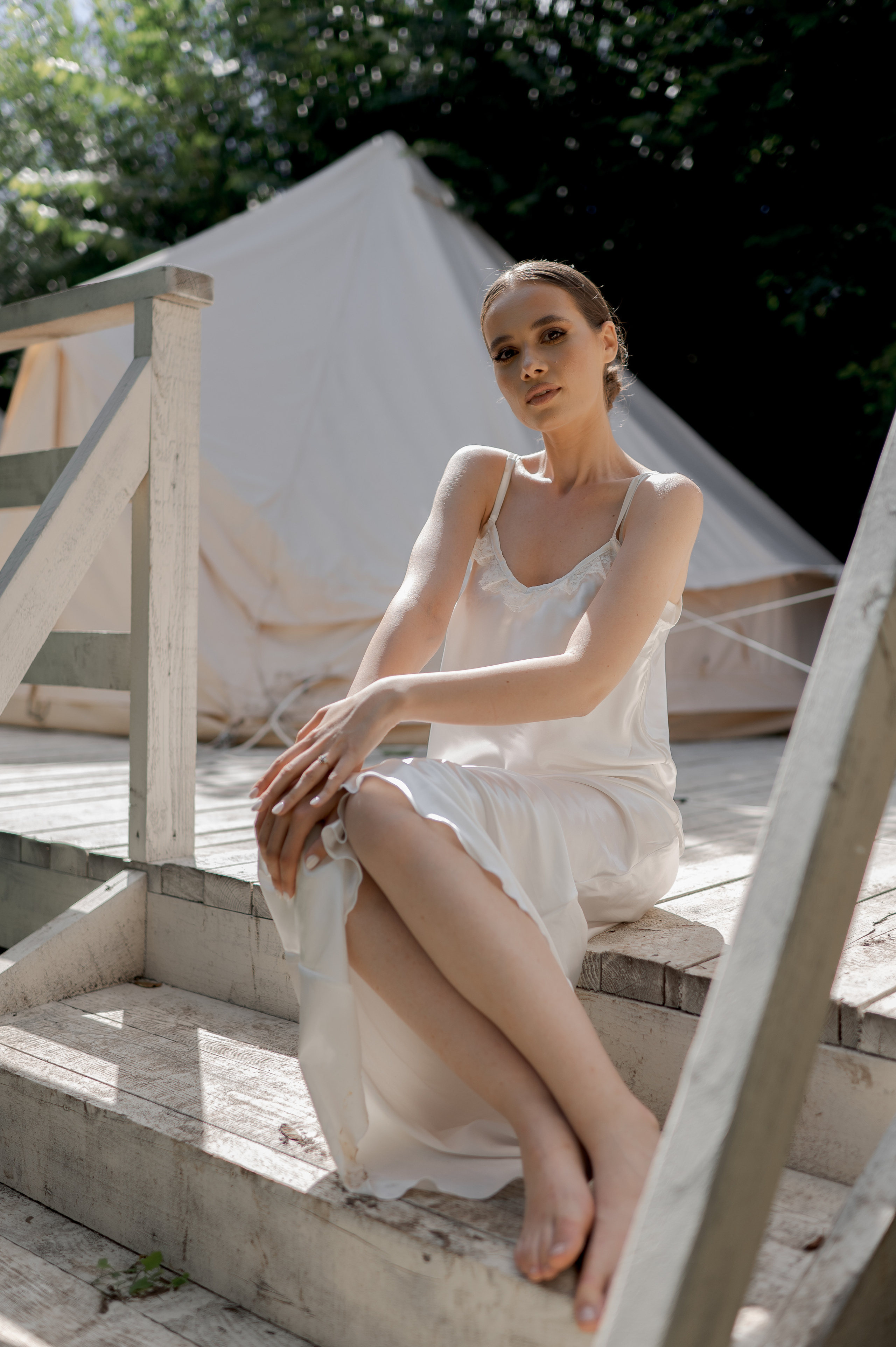 With a sense of anticipation, the delicate bride dons her exquisite satin dress during the serene wedding morning, embodying grace and poise.