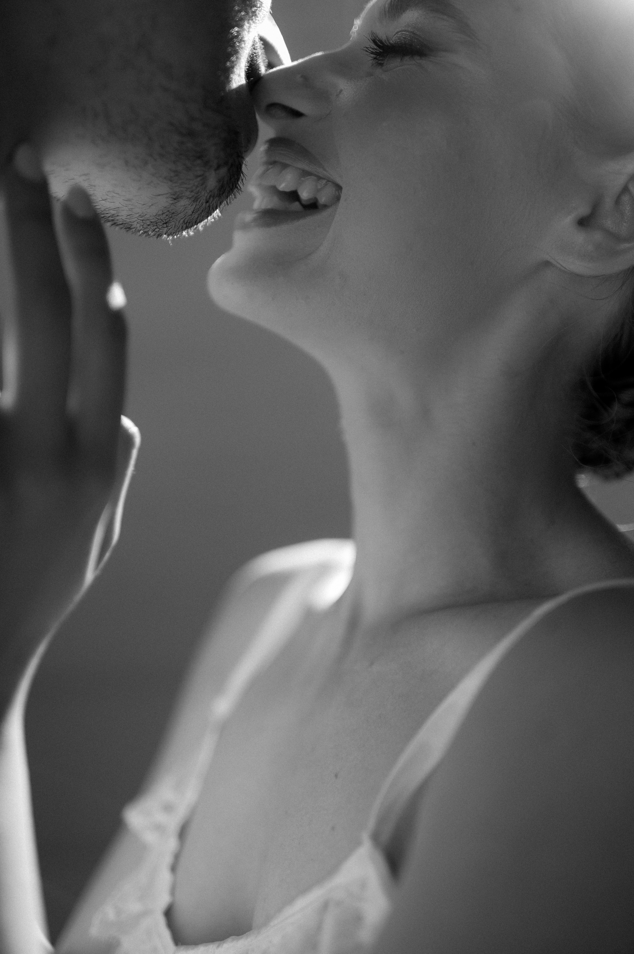 The photographer skillfully captures the couple's infectious laughter during a sweet kiss, showcasing the exquisite details of their engagement ring, adorned with a unique and radiant stone.