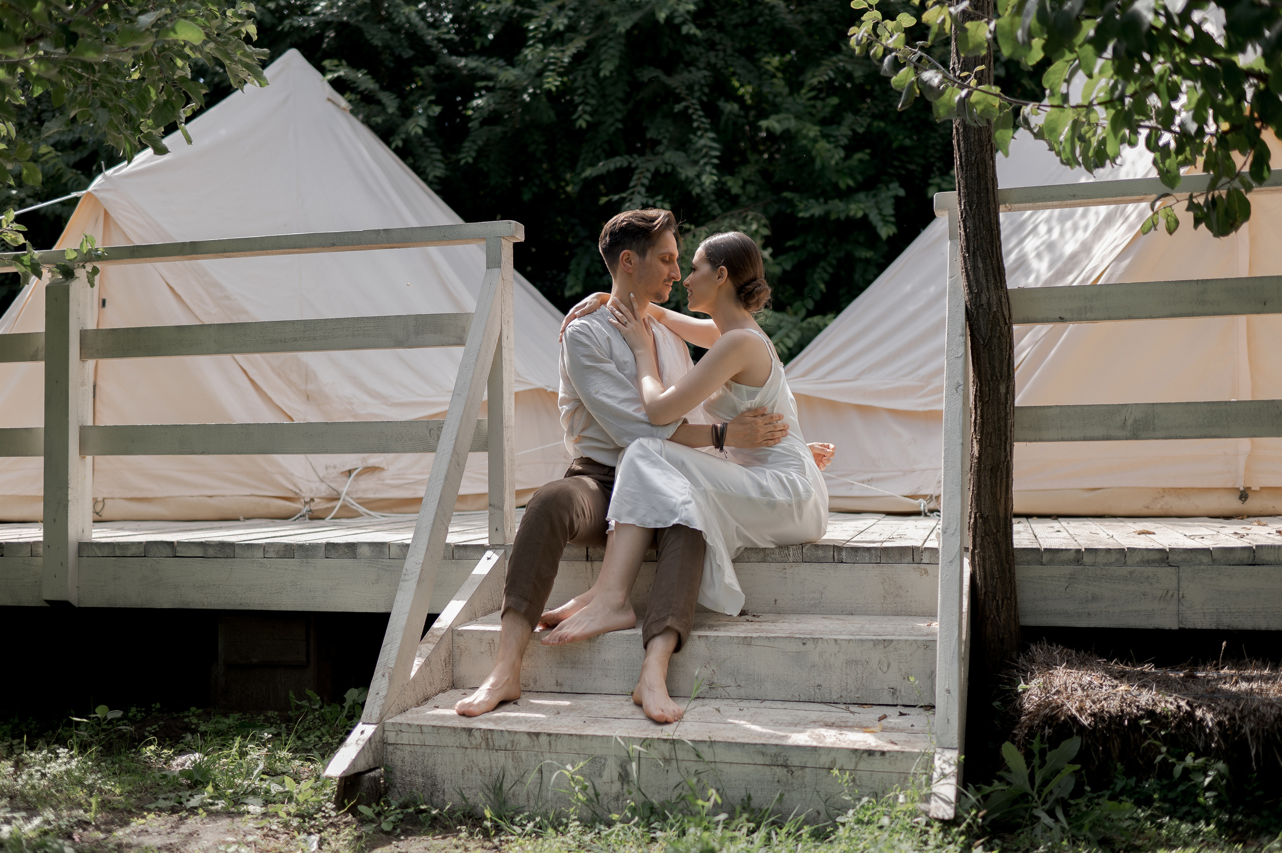 In the enchanting seclusion of a garden retreat, the couple's wedding morning unfolds, surrounded by charming glamping tents, creating an atmosphere of intimacy and romance.