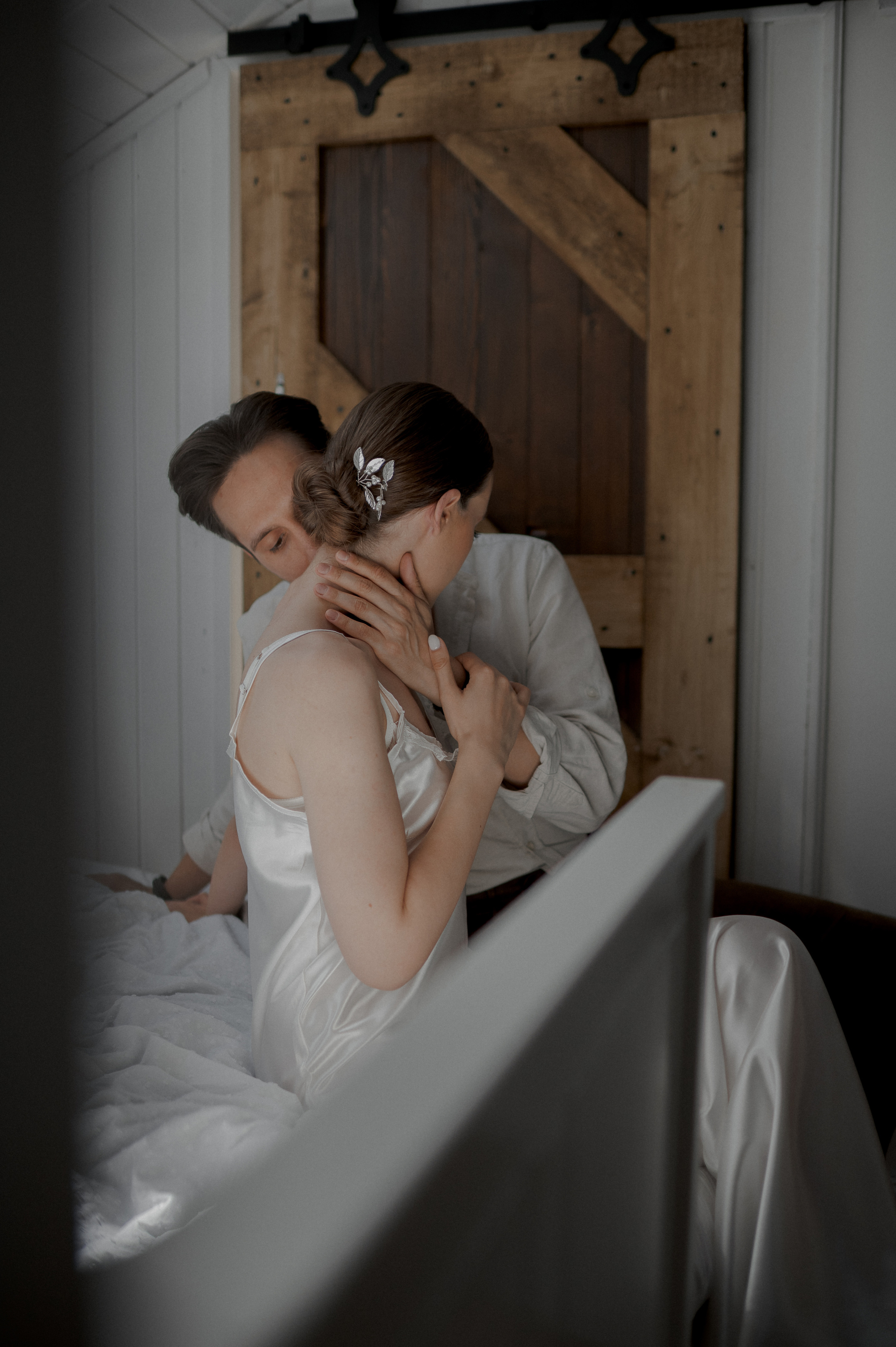 The photographer captures the profound intimacy between the couple, secluded in the privacy of their bed, creating a timeless image that exudes love and connection.