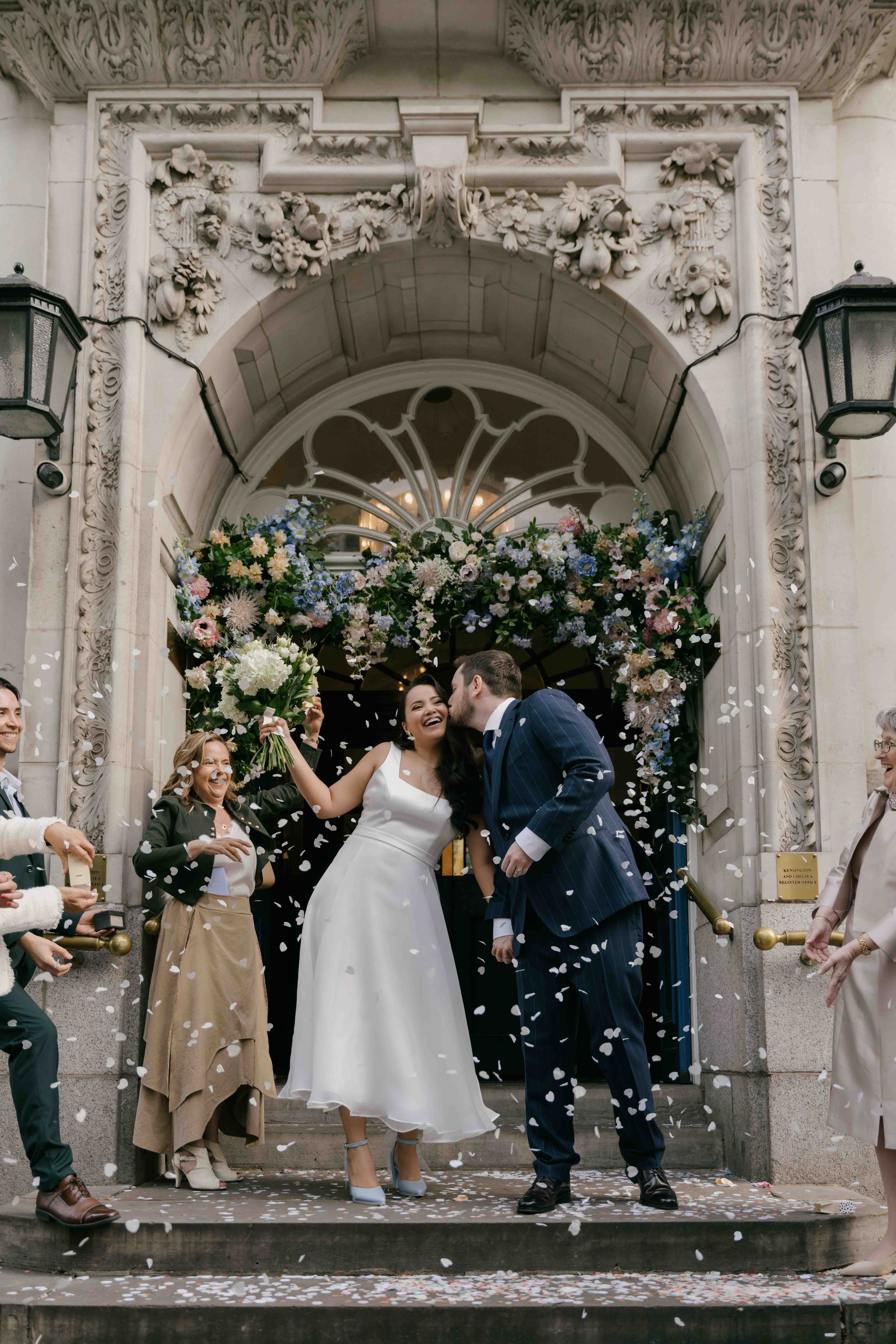 Confetti exit at Chelsea Town Hall London wedding, newlyweds celebrating outside registry office, natural and emotional candid moment