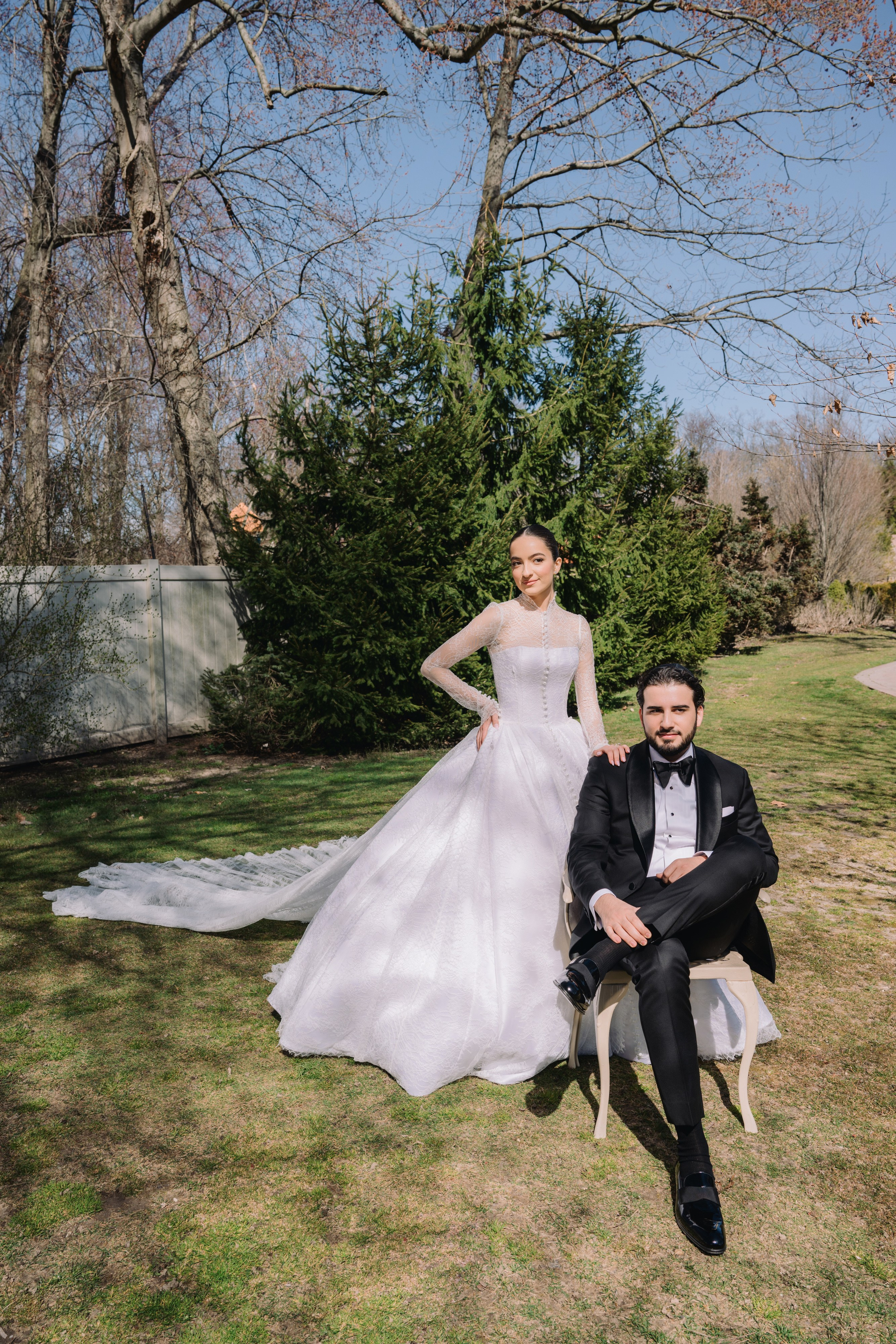 a bride and groom pose for a photo in the park