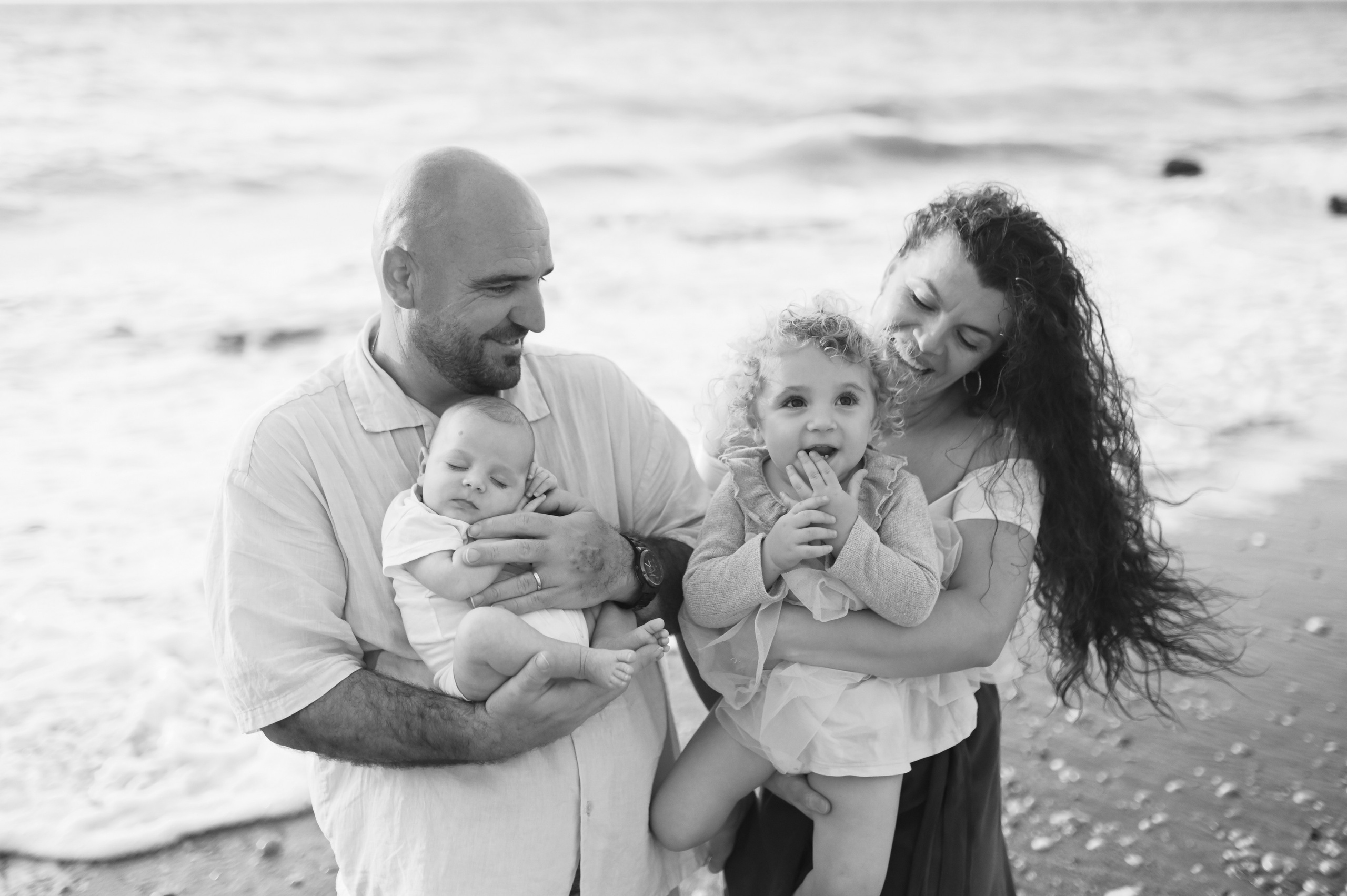 Happy family walking along a Rhodes beach at sunset. Photographer in Rhodes Island