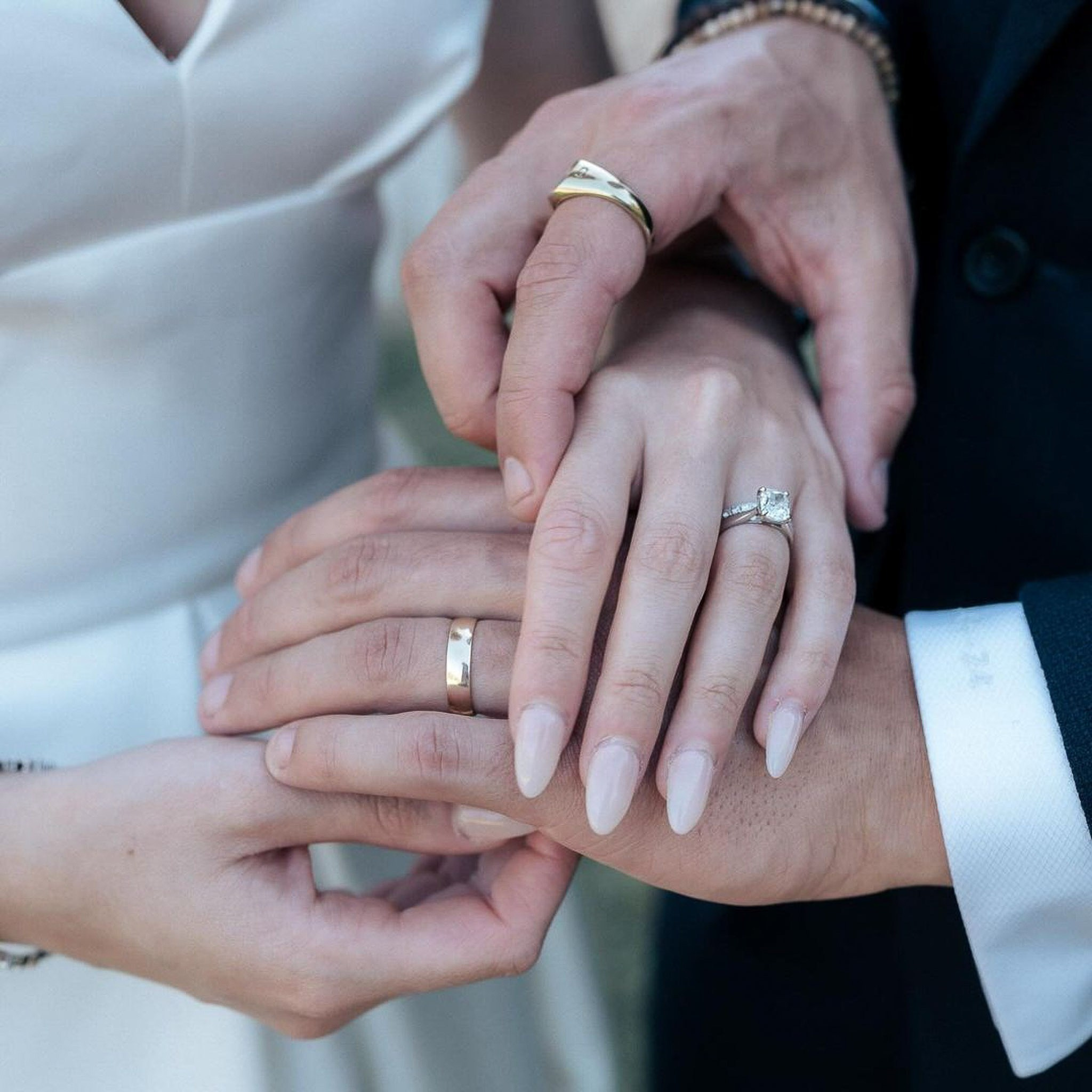 Close-up of the newlyweds' hands showing their wedding and engagement rings