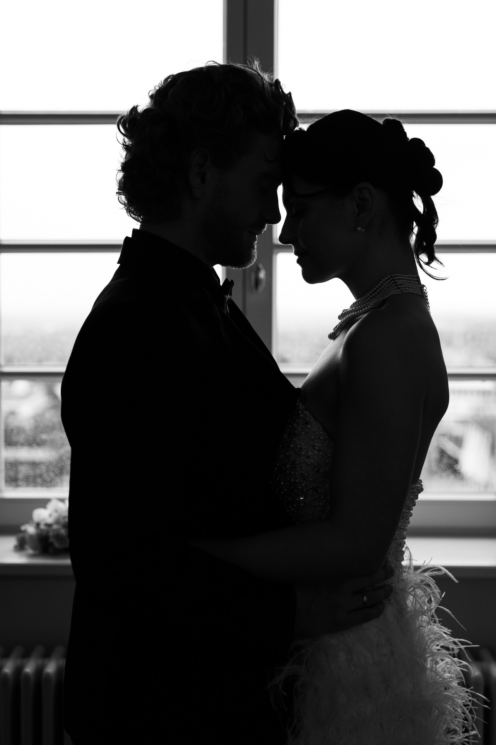 Silhouette eines Brautpaares am Fenster, romantische Hochzeitsfotografie.