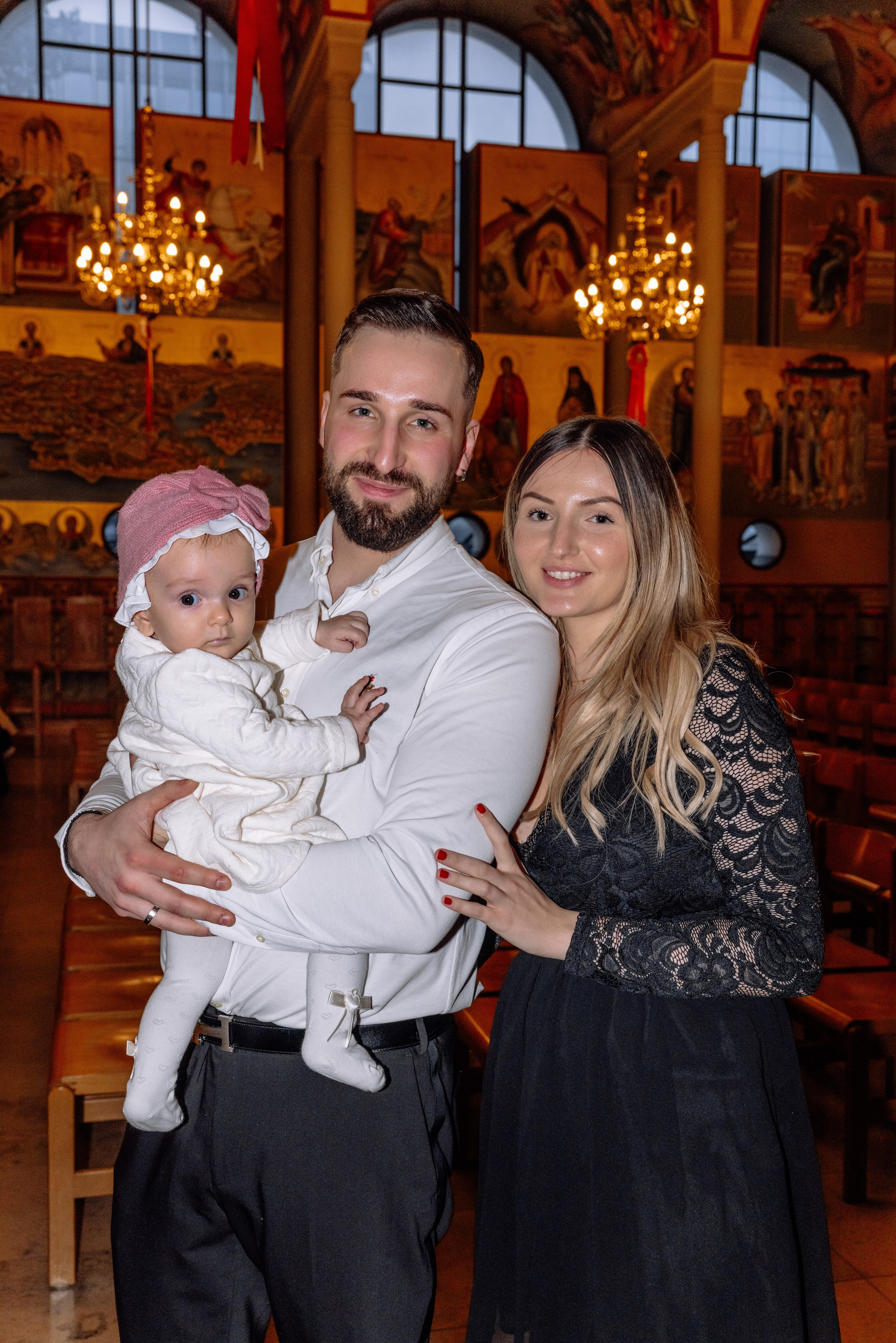 Eltern halten Baby während der Taufe – emotionale Momente Allach