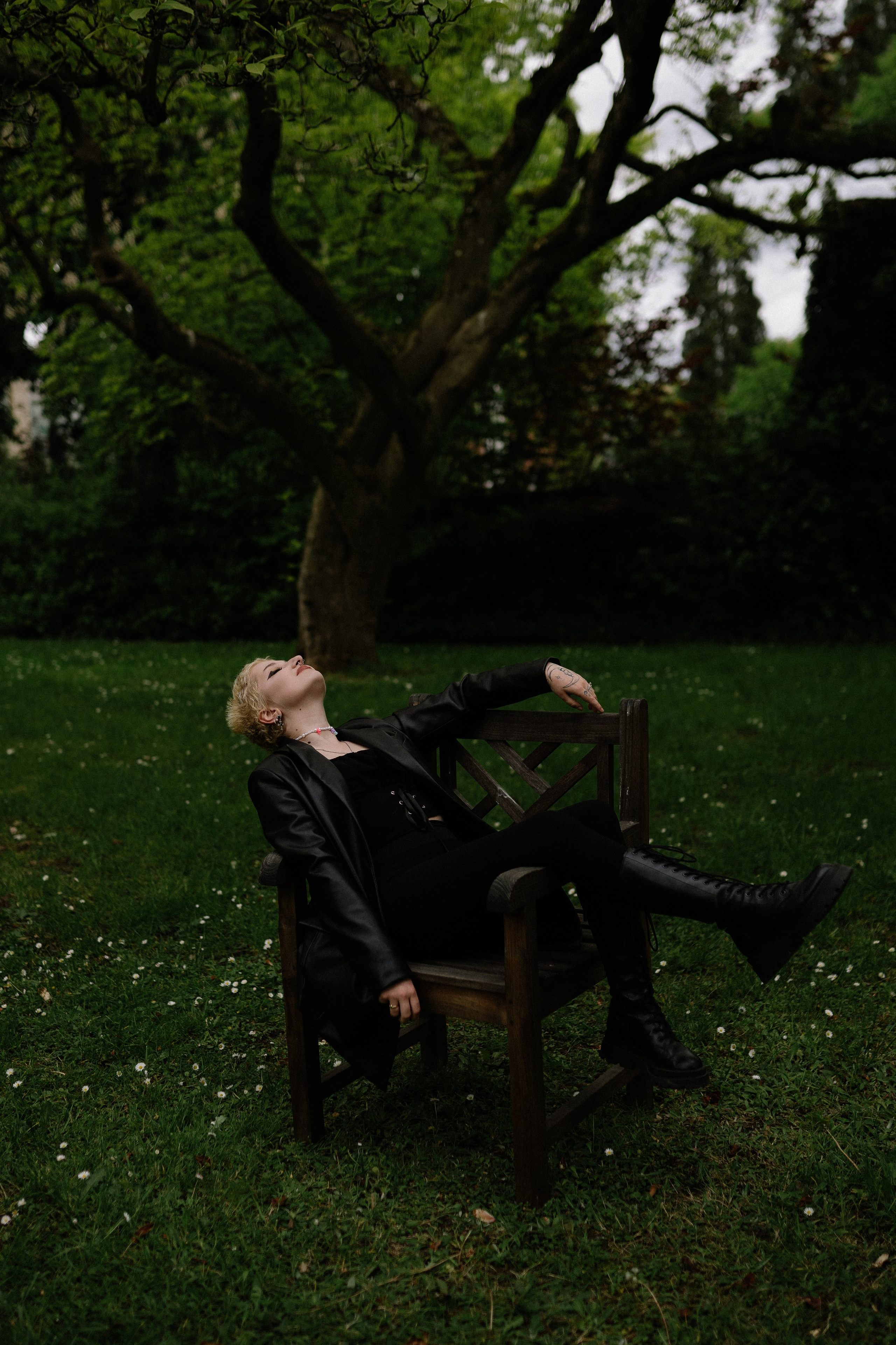 Frauenporträt im Garten auf einem Stuhl, das durch die Verbindung von Natur und Stil fasziniert