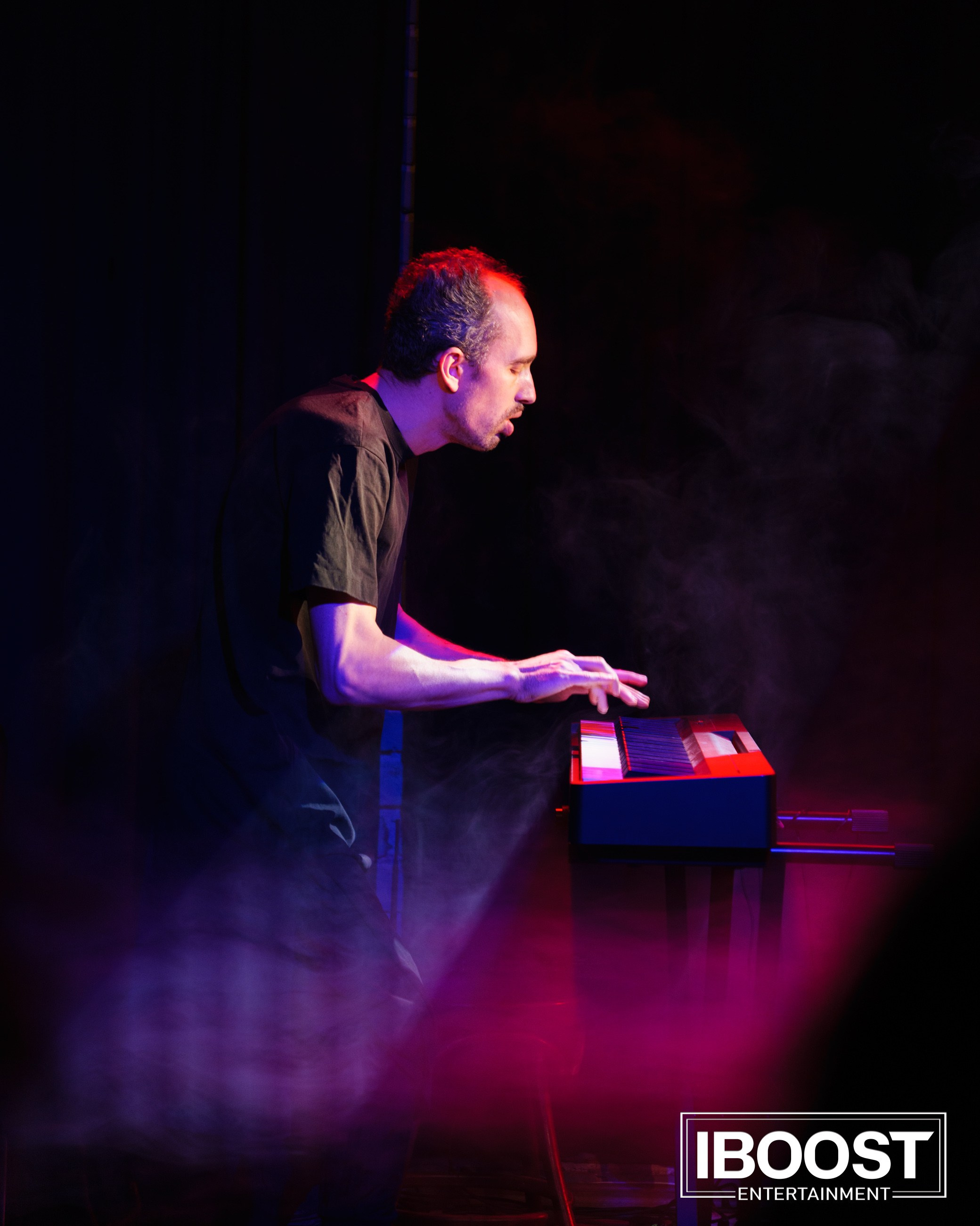 Keyboardist of Animal JazZ performing on stage in Sofia with smoke and purple light.