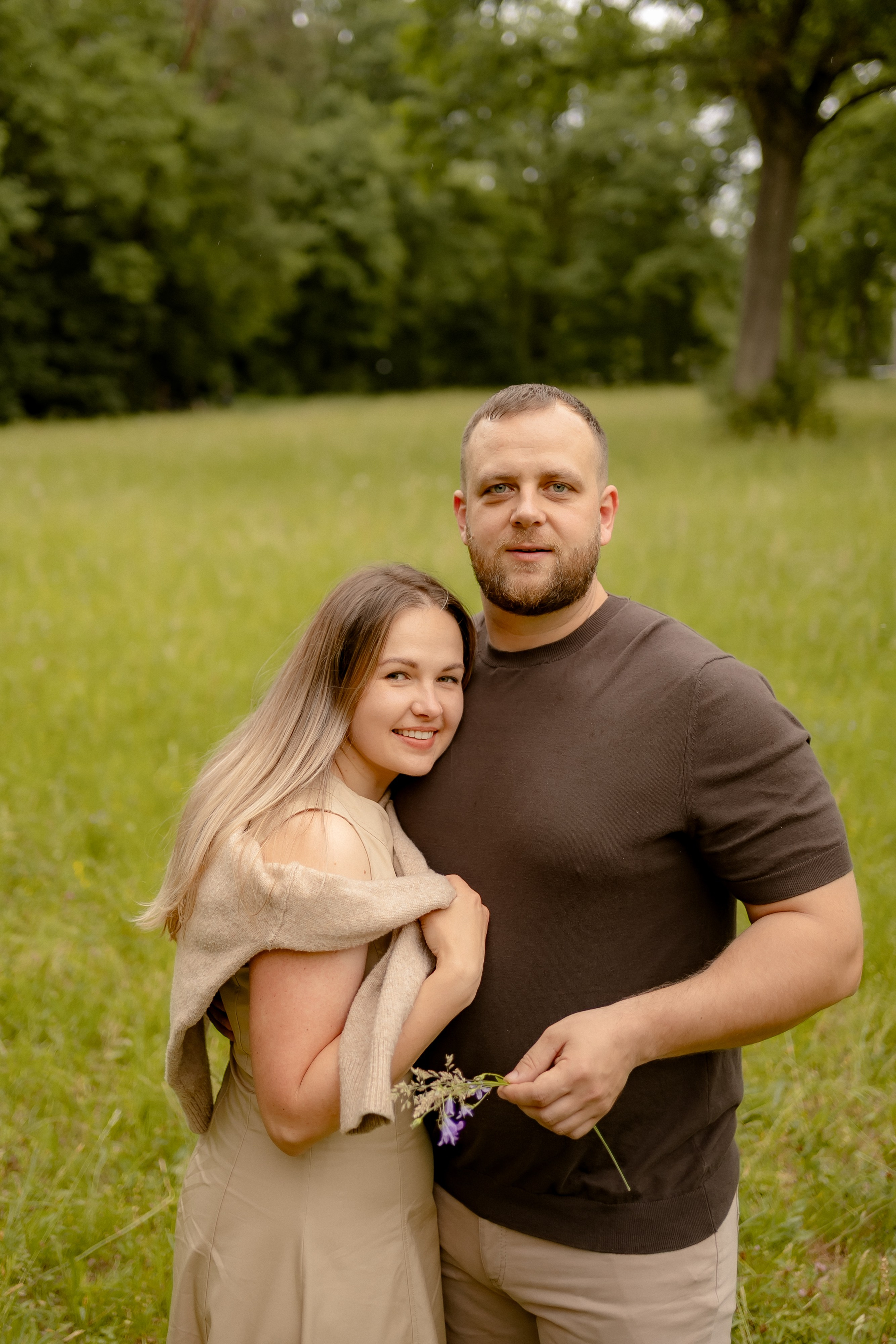 Paar steht eng beieinander auf einer Wiese bei einem Familienfotoshooting.