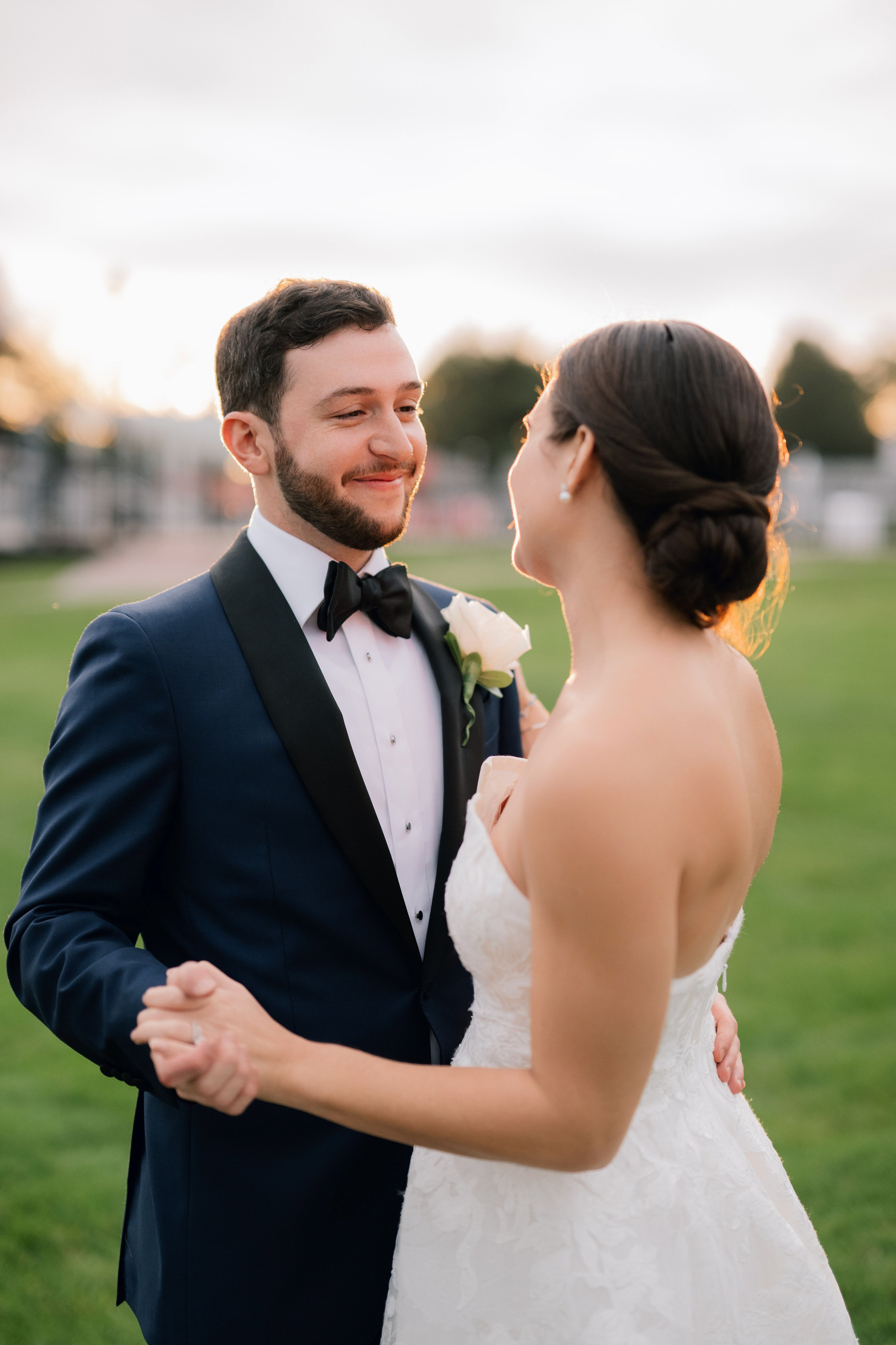 a bride and groom are standing in the grass