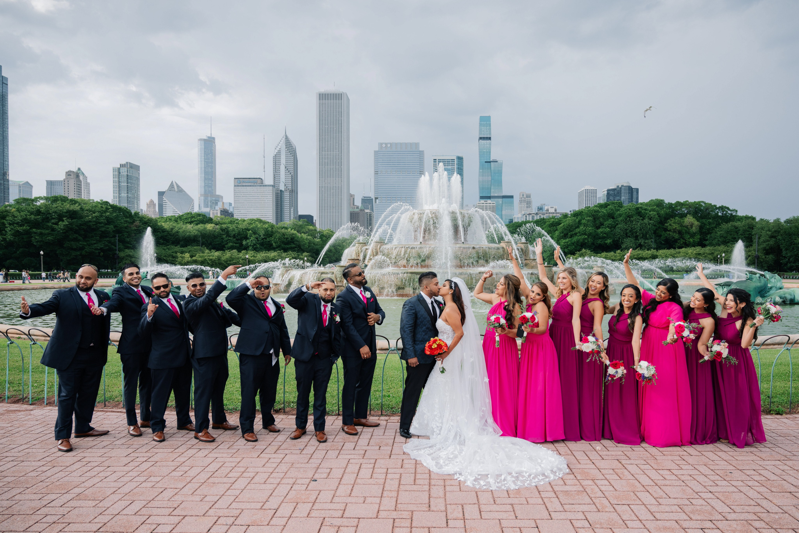 a wedding party poses in front of the buckingham museum