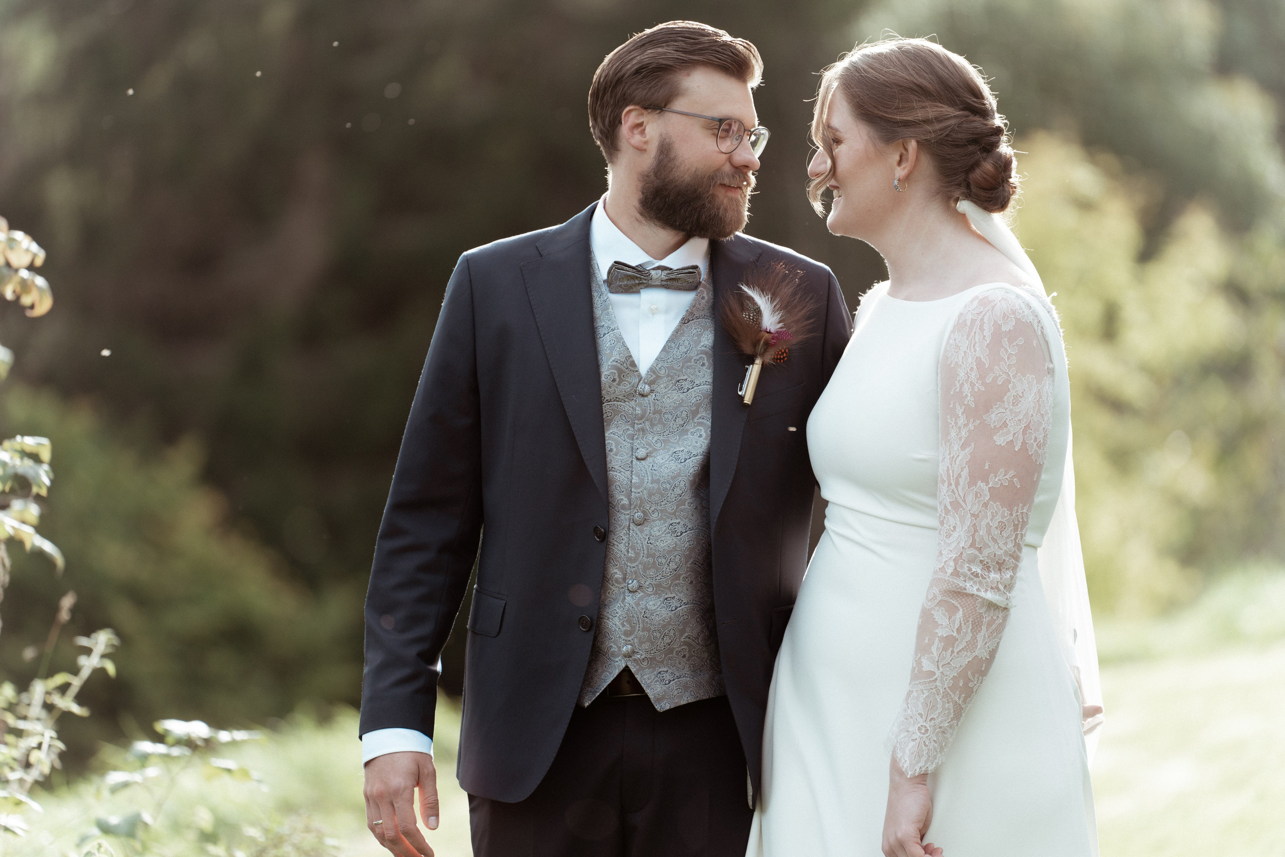 Det vakre brudeparet står ved siden av hverandre og ser på hverandre en sensommerdag