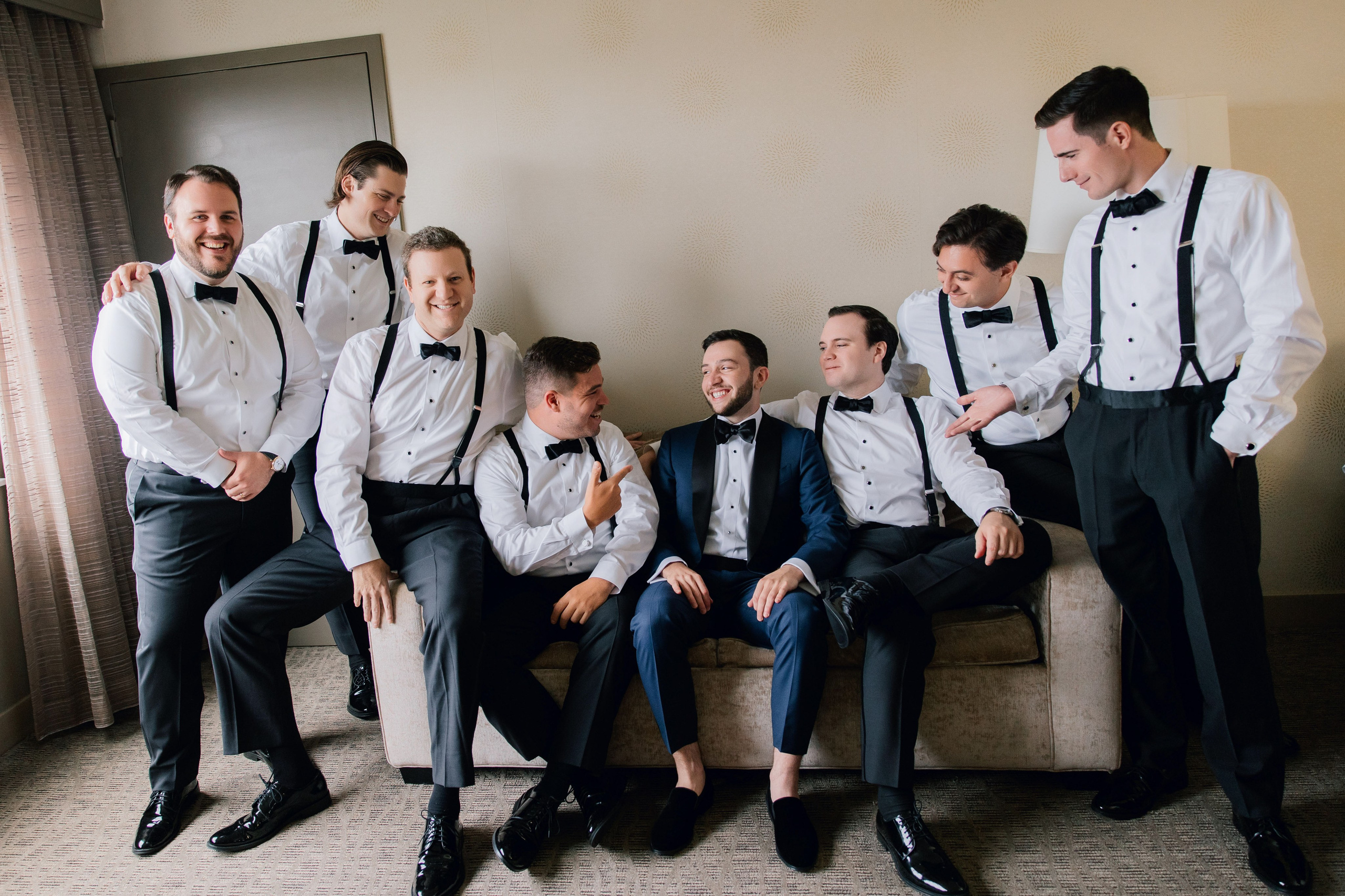 a group of men in formal attire sitting on a couch