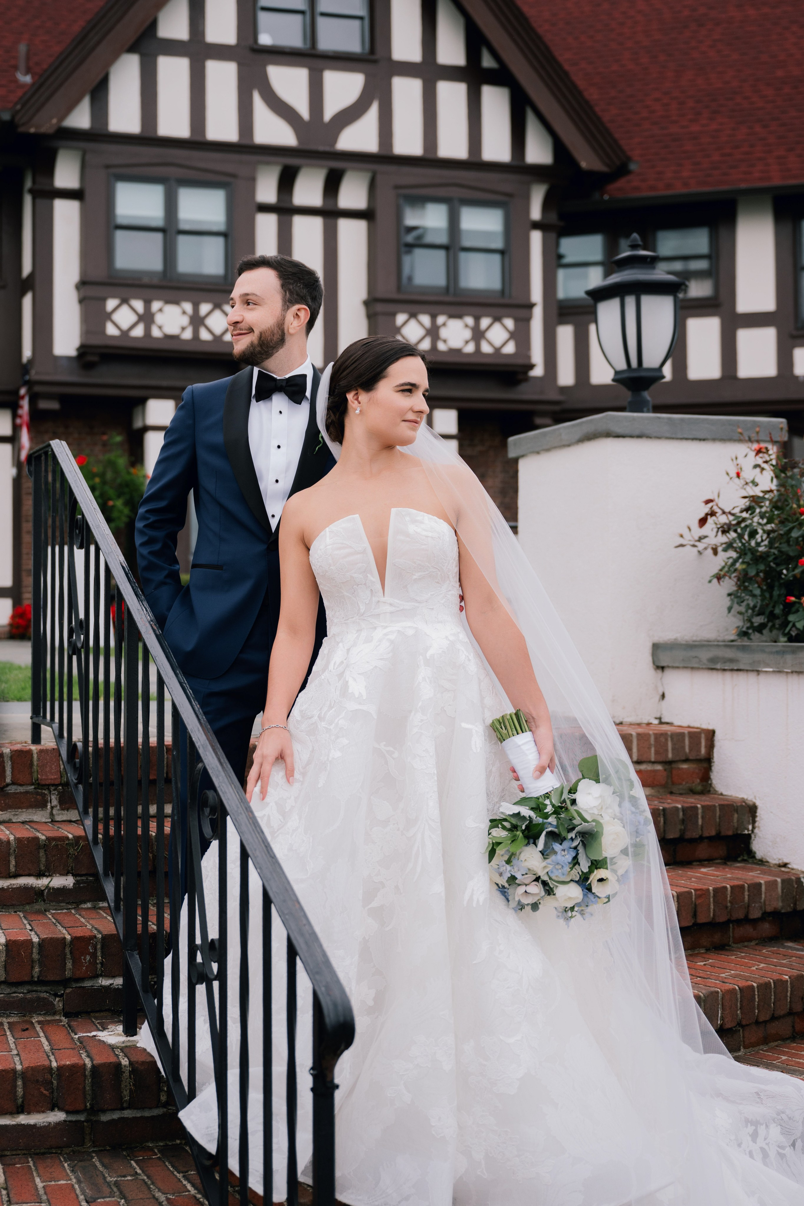 a bride and groom standing on a staircase