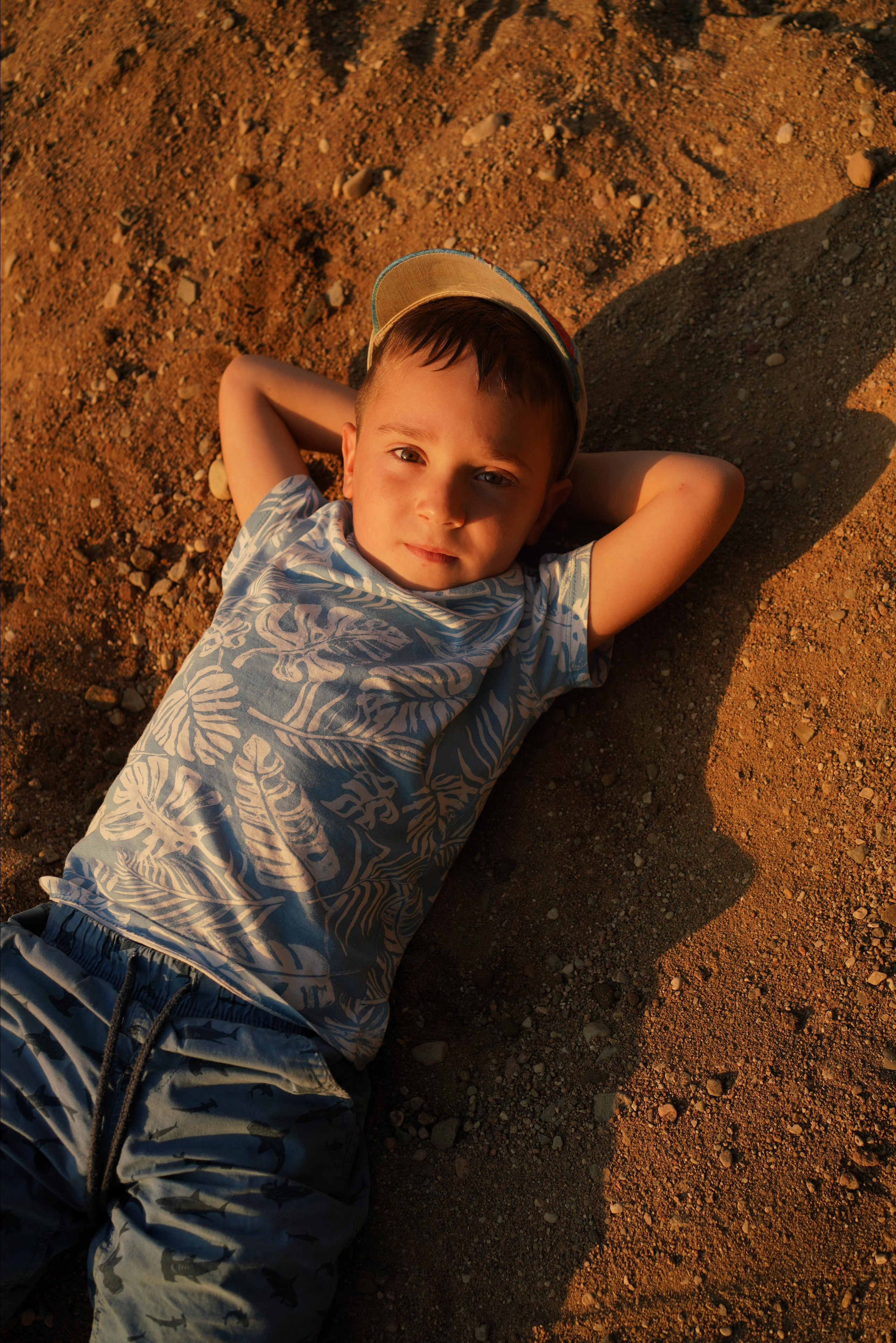 Junge liegt auf dem Boden und hat die Hände hinter dem Kopf