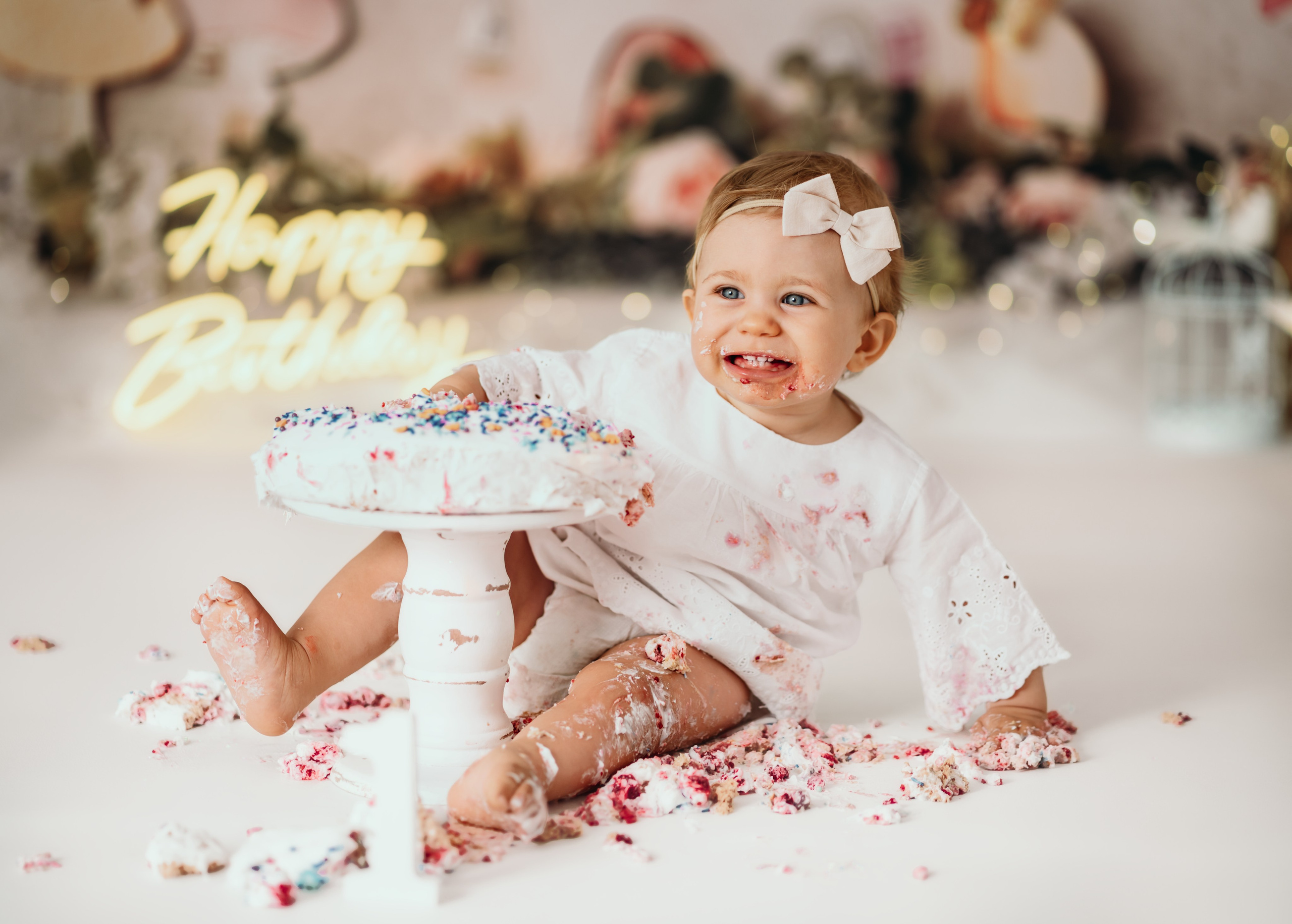 Cake smash Beograd – devojčica sa tortom i lampicama u bajkovitoj sceni