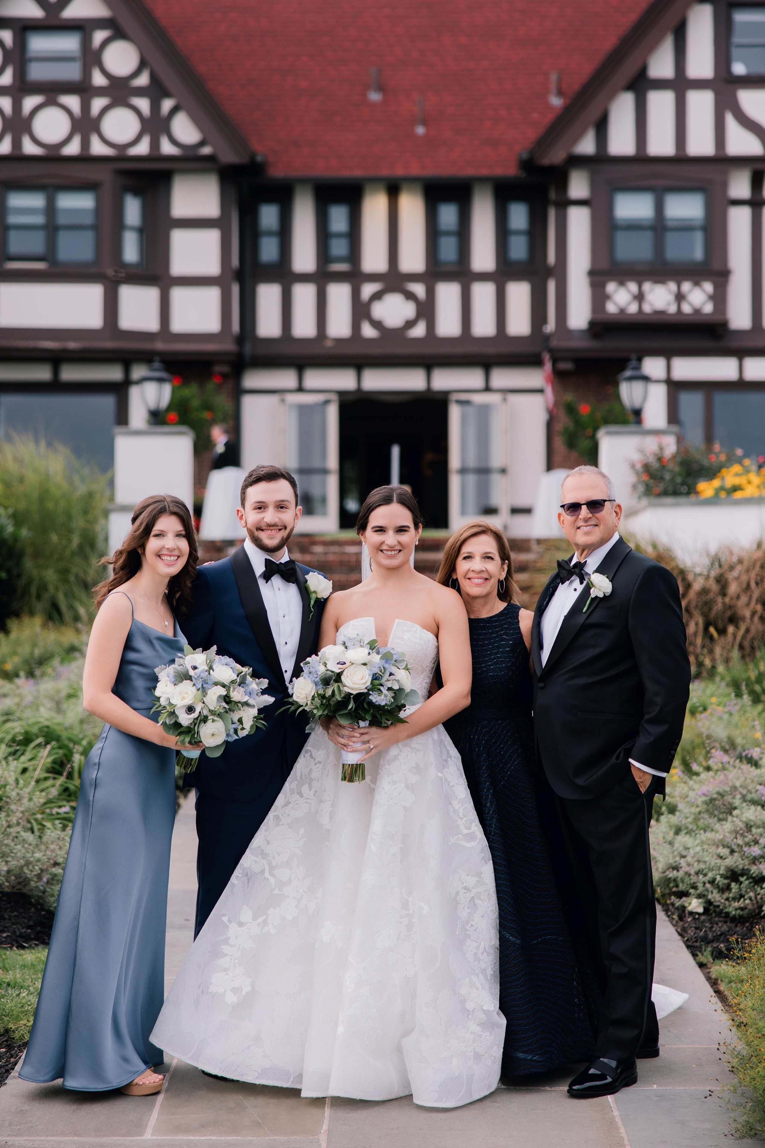 a bride and groom pose with their bridesmaids