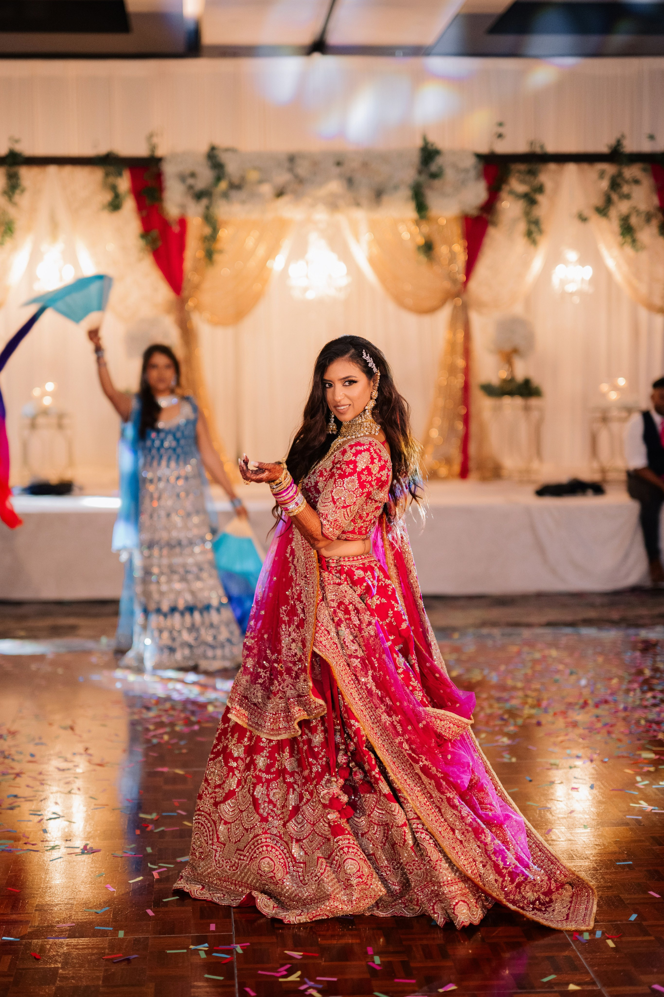 a bride dancing in a pink lehen