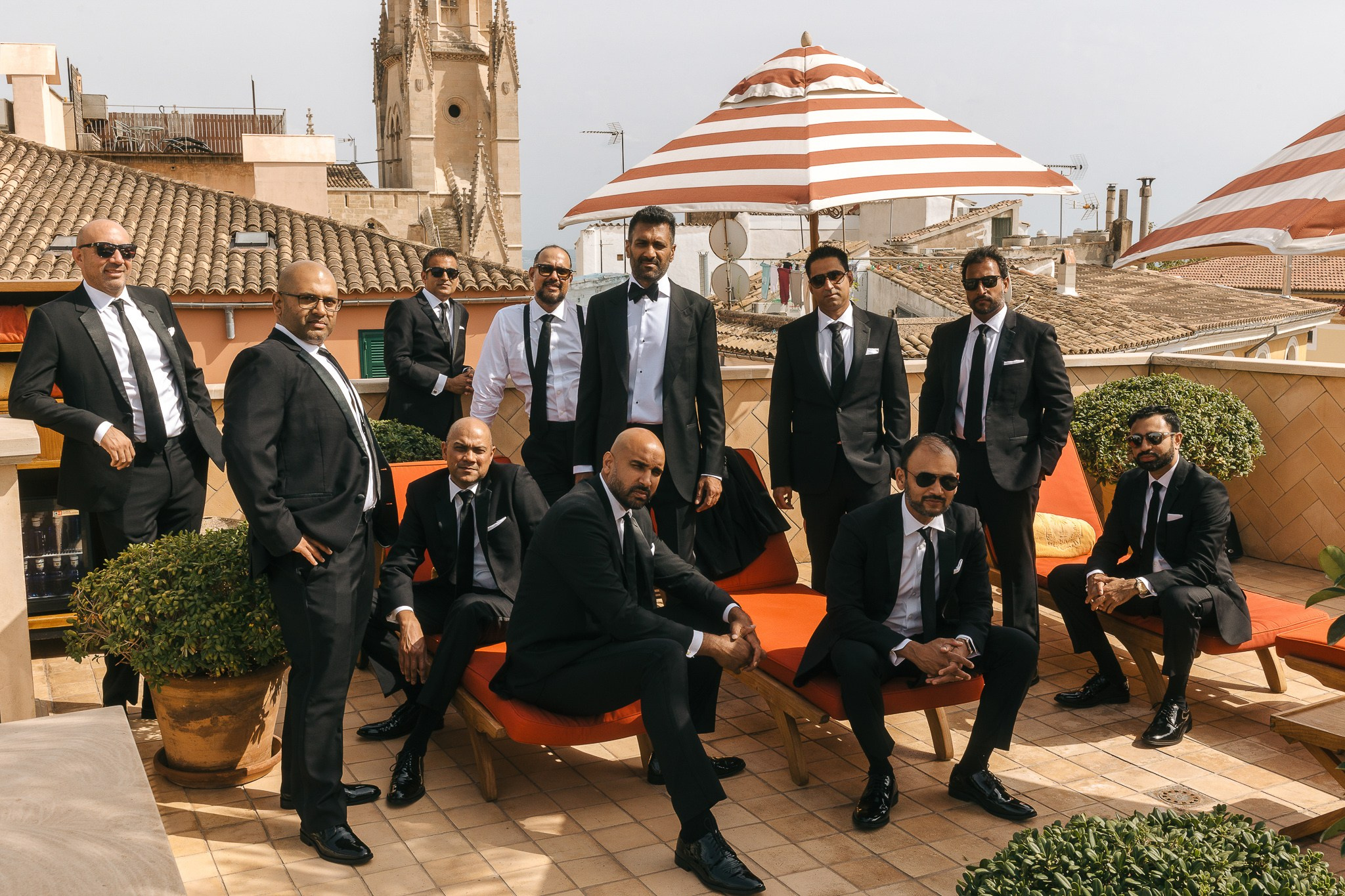 Groomsmen posing together on a rooftop terrace before the Mallorca wedding