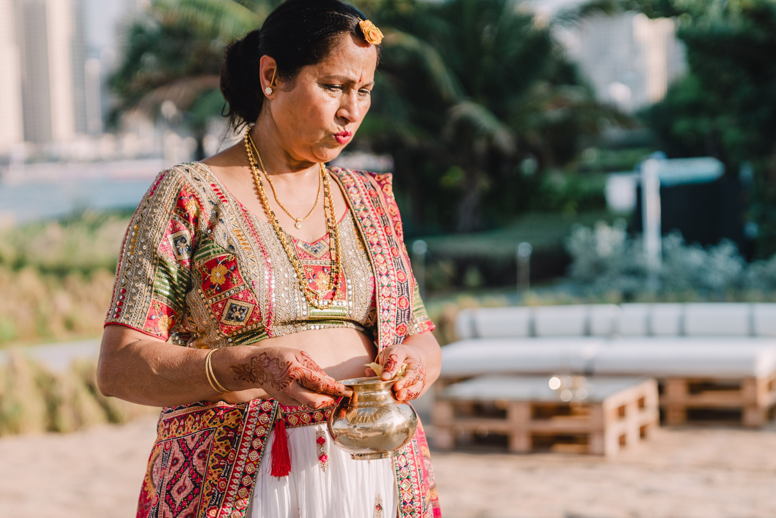 Woman in traditional indian sari with a gold colorful decanter