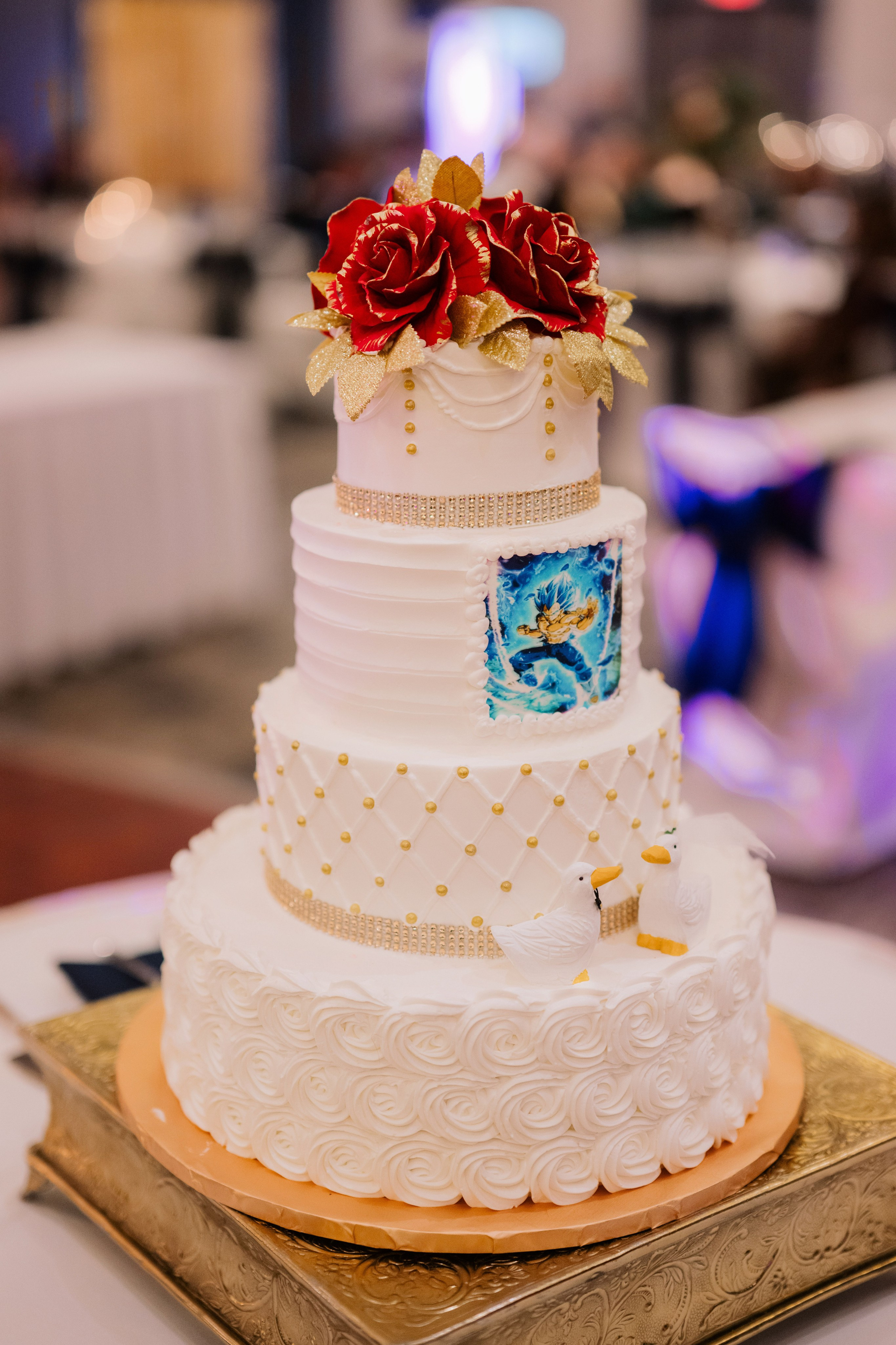 a white wedding cake with red flowers on top