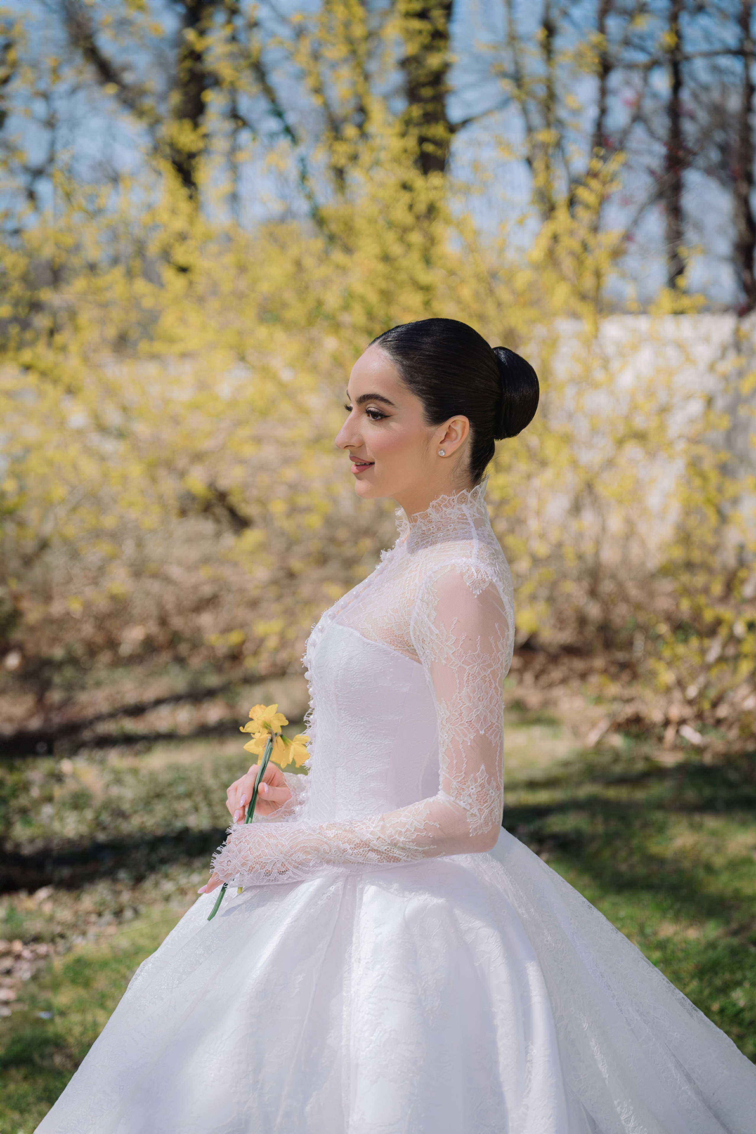 a woman in a white wedding dress standing in the grass