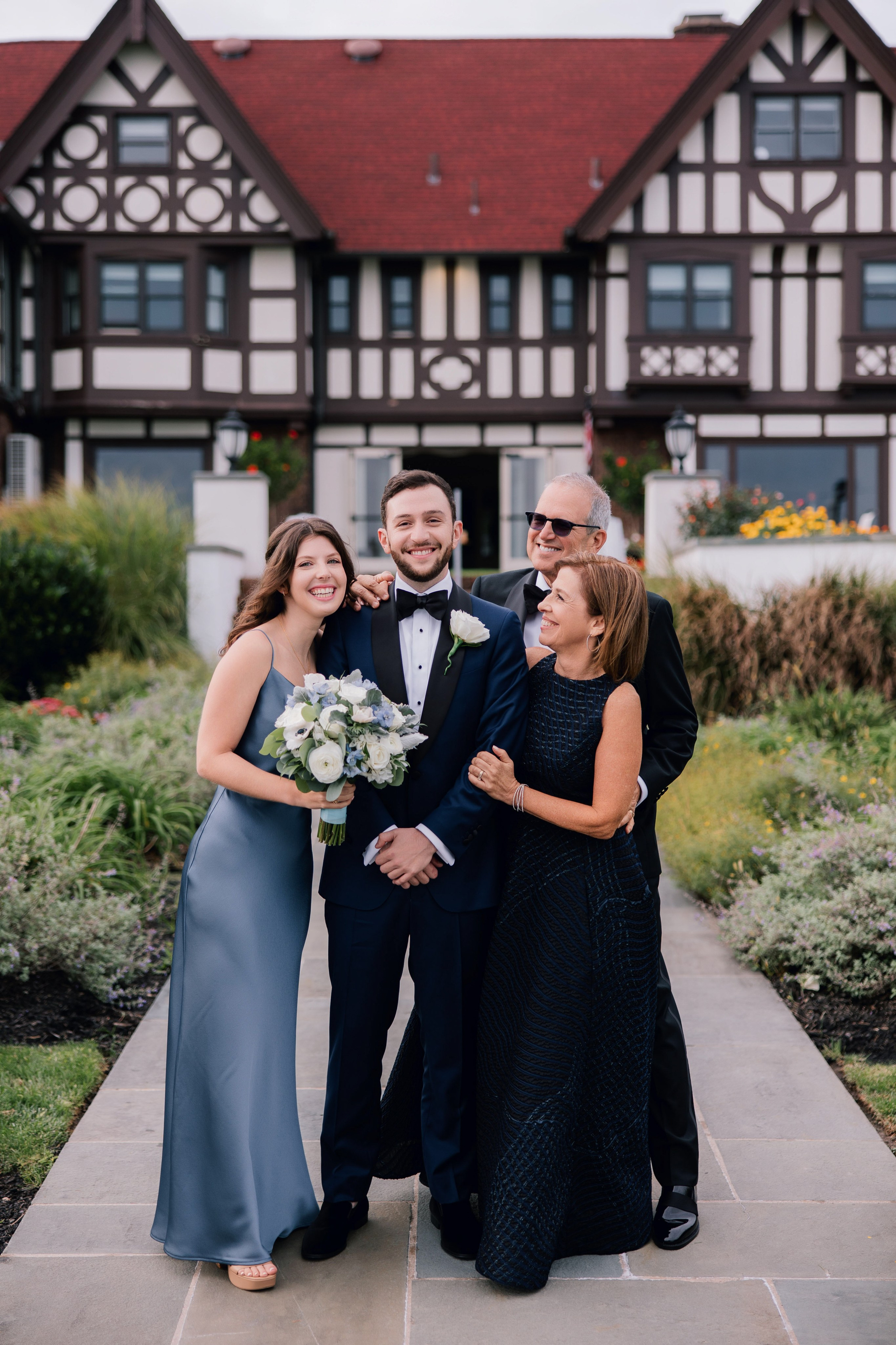 a man in a suit and tie standing next to two women